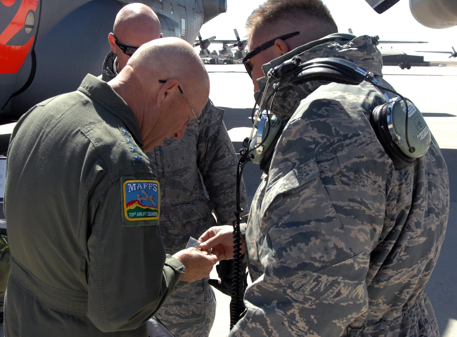 Air Force Gen. Gene Renuart, North American Aerospace Defense Command and U.S. Northern Command commander, accepts a challenge coin from Tech. Sgt. Manuel Ortega, 302nd Aircraft Maintenance Squadron, before his final flight at Peterson Air Force Base May 5. (U.S. Air Force photo by Staff Sgt. Thomas J. Doscher)