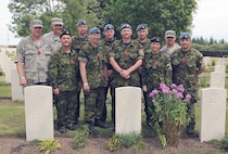 GROESBEEK CANADIAN WAR CEMETERY, The Netherlands – Corporal Dale Ogilvie (middle front), a member of the North American Aerospace Defense Command team from Colorado Springs, Colo., and his team take the time to hold a minute of silence at the grave site of his great uncle. The Canadian Forces Contingent participating in the 94th annual International Four Days marches Nijmegen visited Groesbeek Canadian War Cemetery in the Netherlands. Comprised of 189 marchers, the contingent stopped over halfway through their 40 km walk on the third day of the Nijmegen Marches to pay their respects to some 2,338 Canadian soldiers and airmen who died in the battles to liberate the Netherlands in 1944 and 1945. It is tradition that on the third day of the Nijmegen Marches for the Canadian contingent to halt at he Groesbeek Canadian War cemetery for a memorial ceremony. Many CF members consider their visit to Groesbeek the most important part of the strenuous four-day march, as it represents the history, sacrifice, remembrance and the affection Canadians have received from the Dutch community since the end of World War II. 

(Canadian Forces photo by Cpl. Carole Beggs) 

