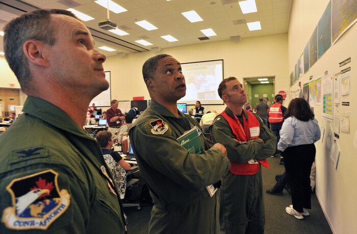 HOUMA, La. – (left to right) Col. Jeff Fiebig, the mobilization assistant to the commander, First Air Force, Tyndall AFB, Fla., Maj. Gen. Garry Dean, the joint force air component commander for North American Aerospace Defense Command and U.S. Northern Command, and Cmdr. Drew Cromwell, air operations branch chief for the Houma Incident Command Post, analyze safety information in the operations center in the central operations room, June 15, 2010. Dean visited the command post to discuss ways the Air Force can assist in the Gulf for the nation’s largest oil spill response and recovery.  U.S. Coast Guard photo by Petty Officer 3rd Class Robert Brazzell.