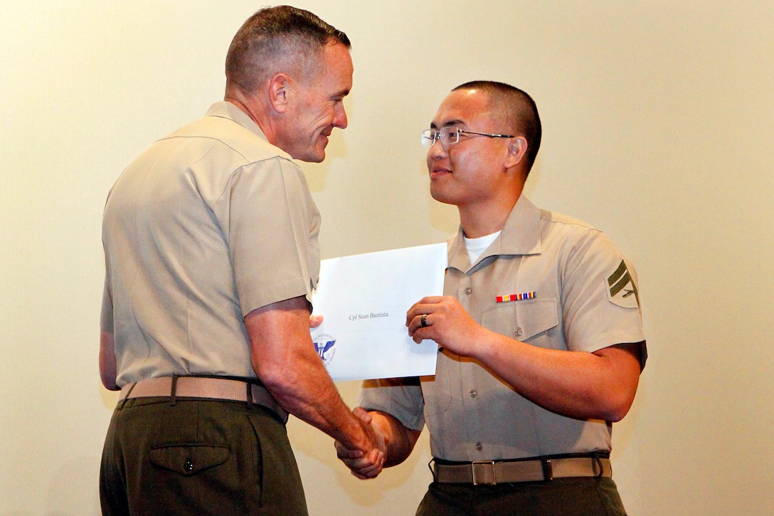 Brig. Gen. Vincent A. Coglianese, left, presents Cpl. Sean Bautista with the 2013 Volunteer of the Year-Military Award Ceremony held at the base theater here April 25. Coglianese is base commanding general and regional authority for five Marine Corps installations in the Southwestern United States. 