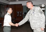 SCHRIEVER AIR FORCE BASE, Colo. – Japan Ground Self Defense Force Maj. Gen. Koichi Isobe, Japan Joint Staff Director for Defense Plans and Policy, shakes hands with Army Lt. Col. David Meakins before a tour of the 100th Missile Brigade at Schriever Air Force Base, Colo., July 15. 

(Photo by Carol Floyd) 

