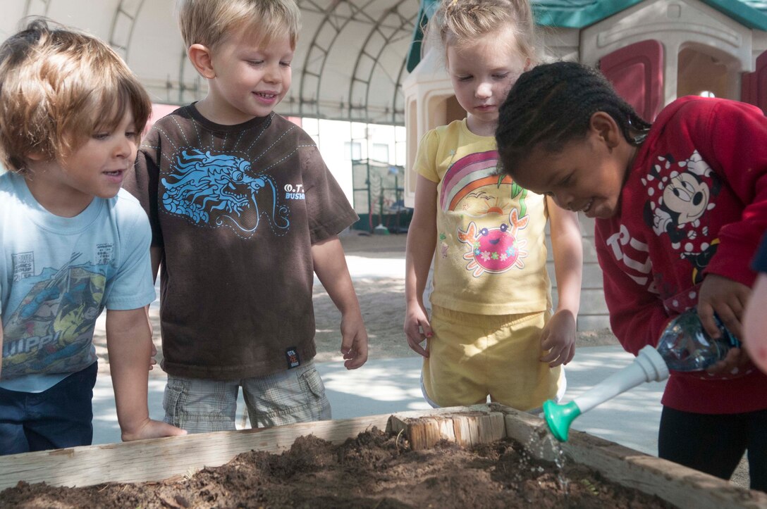 Children from the "Galaxy" class at the Child Development Center aboard Marine Corps Air Station Yuma take turns watering the soil after planting flower and vegetable seeds.  The activity was a part of an MCAS Yuma Earth Day celebration organized and supported by the Environmental Department on April 25. The event raised awareness about Earth Day and our global responsibilities to be caretakers of the land we use here at MCAS Yuma.