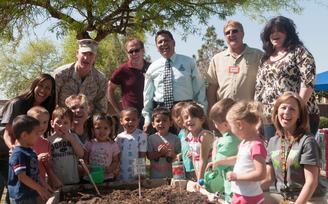 Colonel Robert Kuckuk, Marine Corps Air Station Yuma commanding officer, and station personnel from both the Environmental Department and the Child Development Center take a break from helping children plant flower and vegetable seeds at the CDC April 25. The final event brought a close to the week-long Earth Day celebration to raise awareness about being environmentally conscious caretakers of the land that we live, train and operate on as a community here at MCAS Yuma.