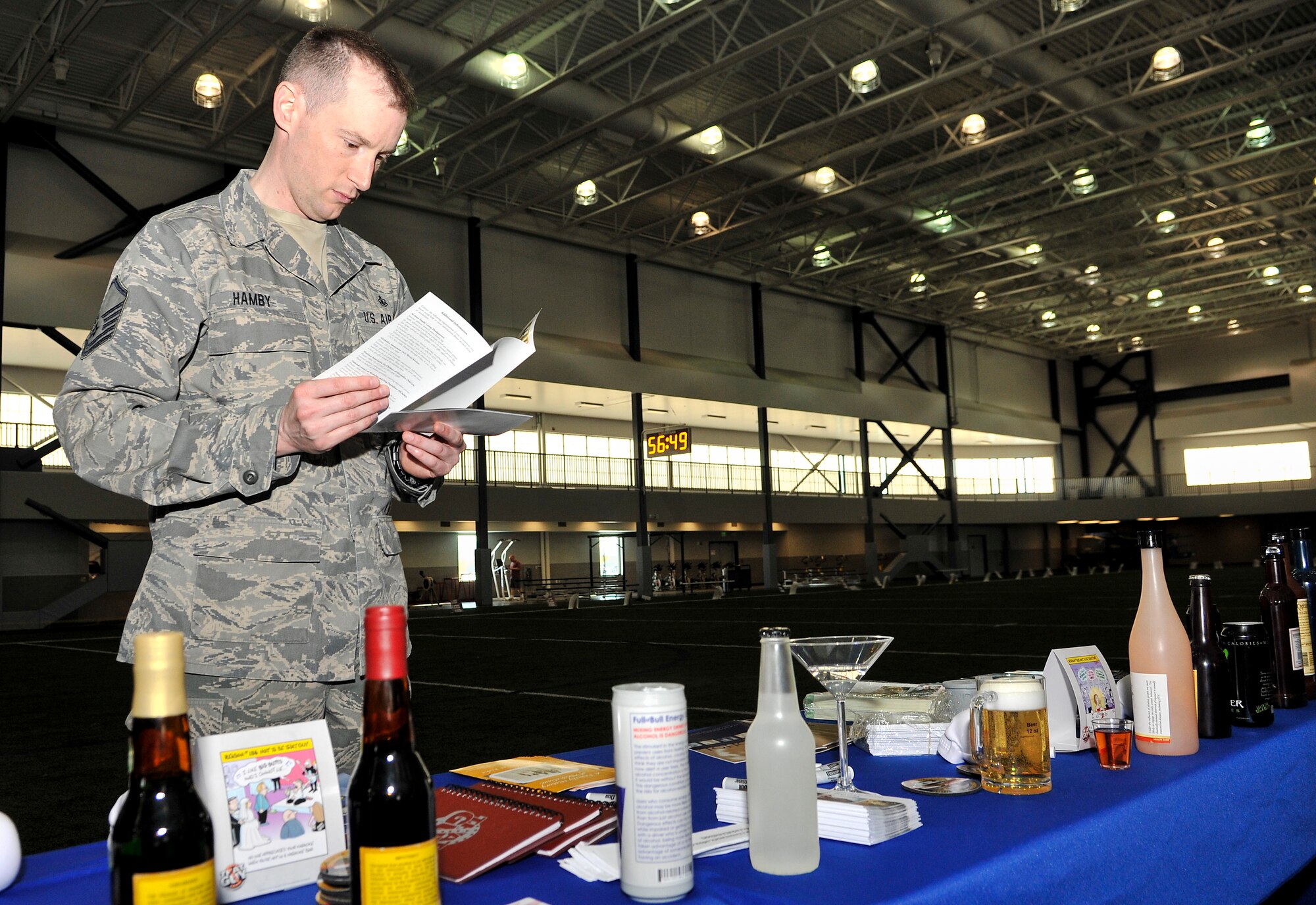 U.S. Air Force Master Sgt. Charles Hamby, 354th Medical Group public health NCO in charge, reads brochures during an alcohol awareness event at the fitness center April 18, 2013, Eielson Air Force Base, Alaska. Eielson’s Alcohol and Drug Abuse Prevention and Treatment office informed people on the dangers of misusing alcohol. (U.S. Air Force photo by Senior Airman Racheal E. Watson/Released)