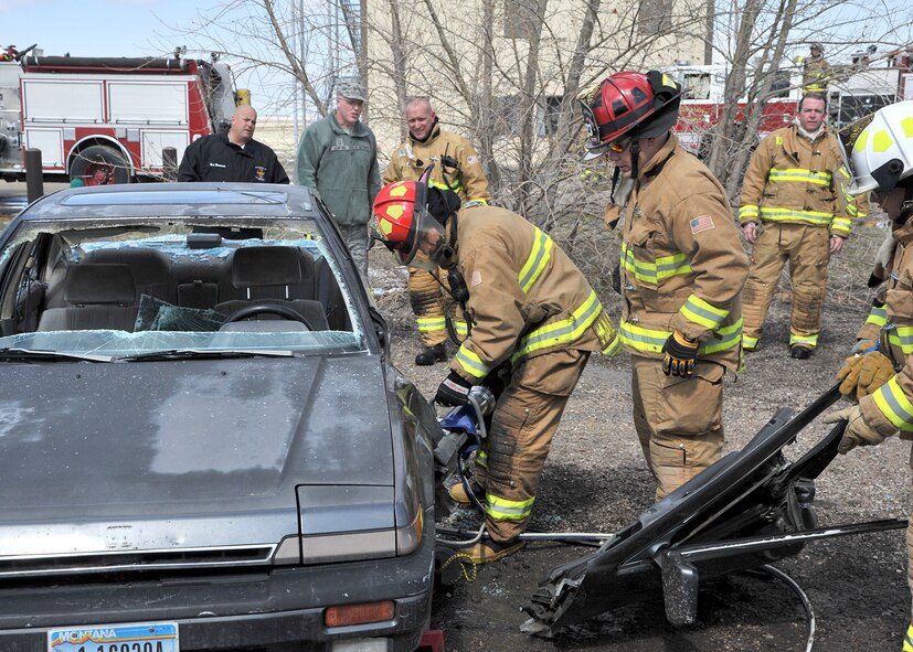 Lt. Gen. James Kowalski, commander of Air Force Global Strike Command, with help from members of Malmstrom’s fire department, uses the Jaws of Life to cut through the side of a vehicle during his tour of the 341st Civil Engineer Squadron Fire Trainer on April 22.  Kowalski visited Team Malmstrom members during a tour of the base April 21 - 24.  (U.S. Air Force photo/John Turner) 