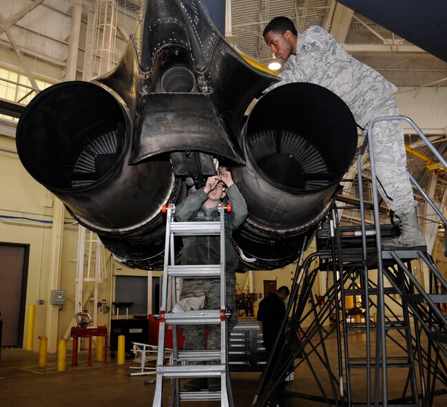 Airmen 1st Class Kyle Gallegos, center, and Jeremy Stewart, 2nd Maintenance Squadron crew chiefs, install a fire wall panel on the engines of a B-52H Stratofortress during a phase inspection on Barksdale Air Force Base, La., April 26, 2013. The panel protects the bleed air and electrical systems incase of engine fire or hostile actions. (U.S. Air Force photo/Airman 1st Class Andrew Moua)