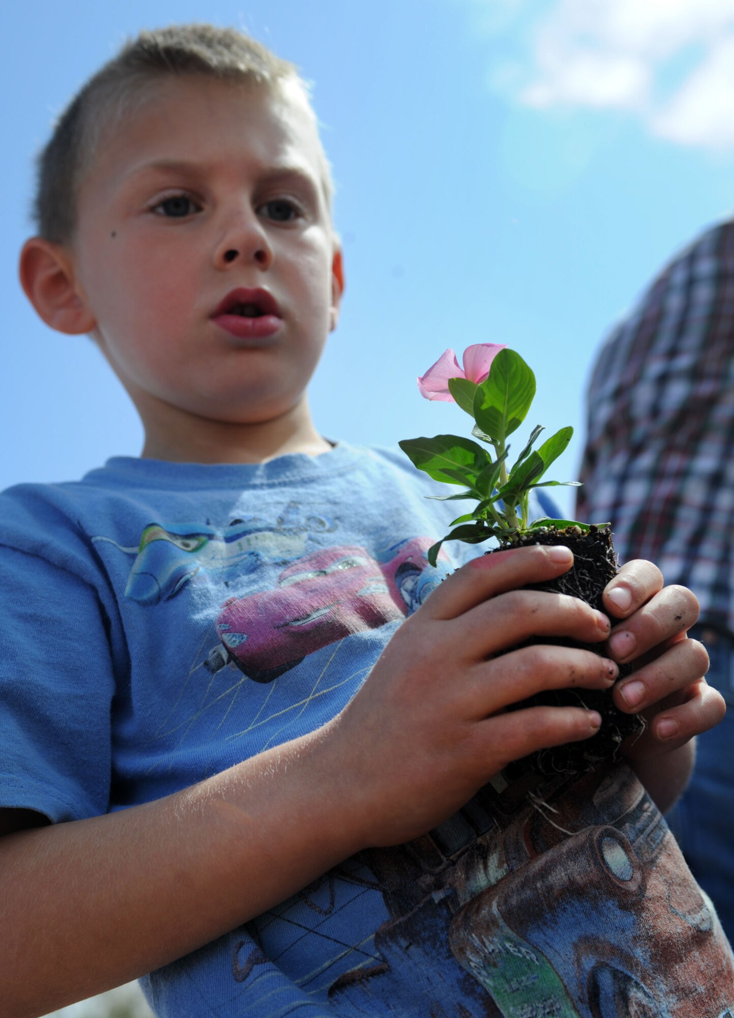 A child prepares to plant flowers outside the Child Development Center at Cannon Air Force Base, N.M., April 25, 2013. The CDC members participated in the planting to celebrate Earth Day and Arbor Day. (U.S. Air Force photo/Airman 1st Class Ericka Engblom)