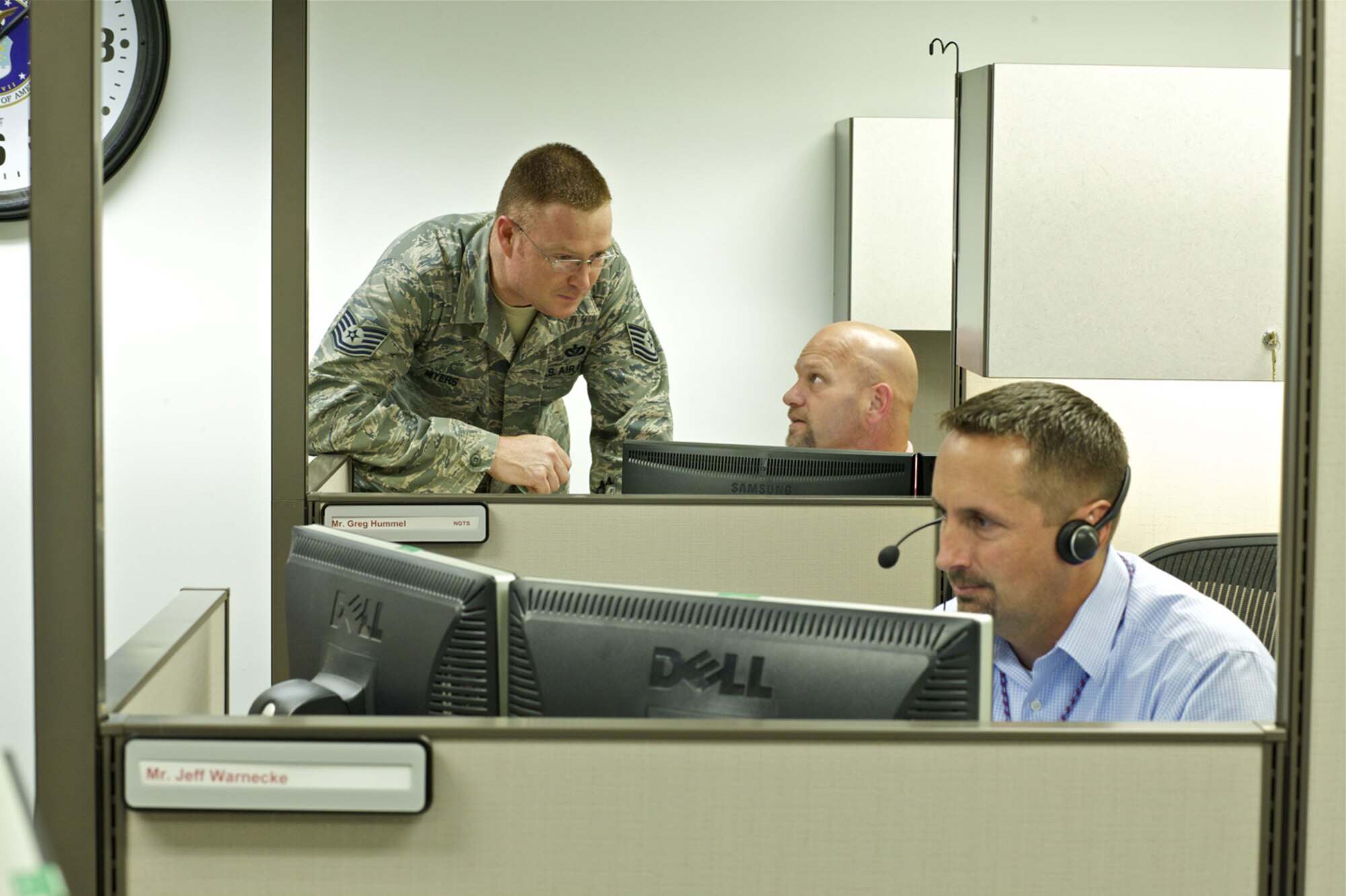 TYNDALL AIR FORCE BASE, Fla. -- AFCEC Reach-Back Center Agent Greg Hummel, discusses a customer’s request for technical information with Tech. Sgt. Jason Myers of AFCEC’s Readiness Directorate as Jeff Warnecke in the foreground updates the RBC’s database. Since 2005, the RBC has handled more than 50,000 requests for information. Agents field questions from deployed locations, the Pentagon, major commands, bases, industry, and other services. The RBC also supports AFCEC’s experts by maintaining a vast database of civil engineer information that they can quickly reference in response to customers’ queries. (U.S. Air Force photo/Eddie Green)