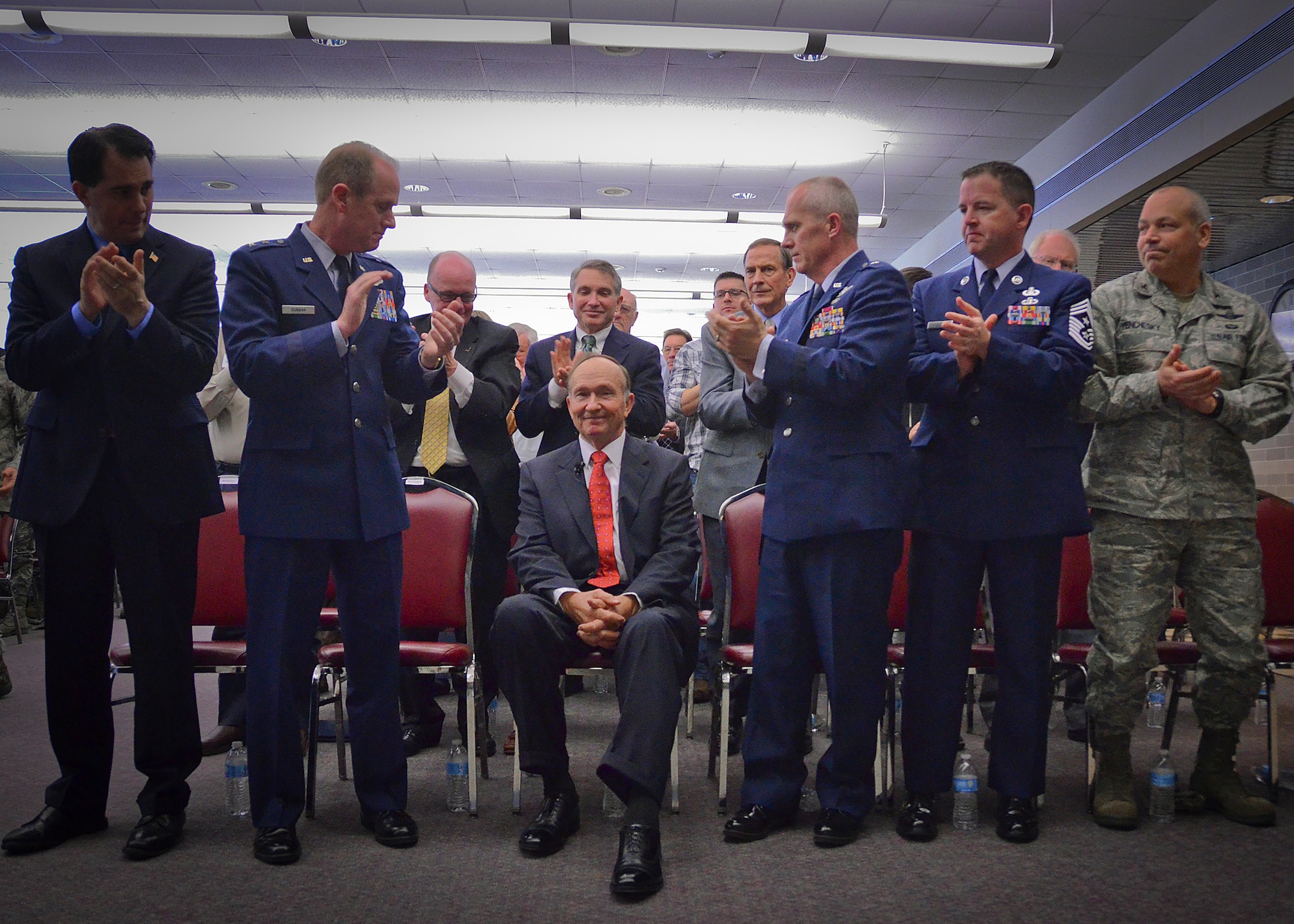 Capt. Guy Gruters, seated at center, receives a standing ovation from (from left) Wisconsin Governor Scott Walker, Maj. Gen. Donald P. Dunbar, adjutant general of Wisconsin, Brig. Gen. Gary L. Ebben assistant adjutant general for Air and Command Chief Master Sgt. Gregory Cullen following his address at Milwaukee’s 128th Air Refueling Wing Thurs., April 25 2013.
Gruters, a Vietnam War prisoner of war, spent more than five years in an enemy prison camp.  (U.S. Air National Guard photo by 1st Lt. Nathan Wallin/Released)