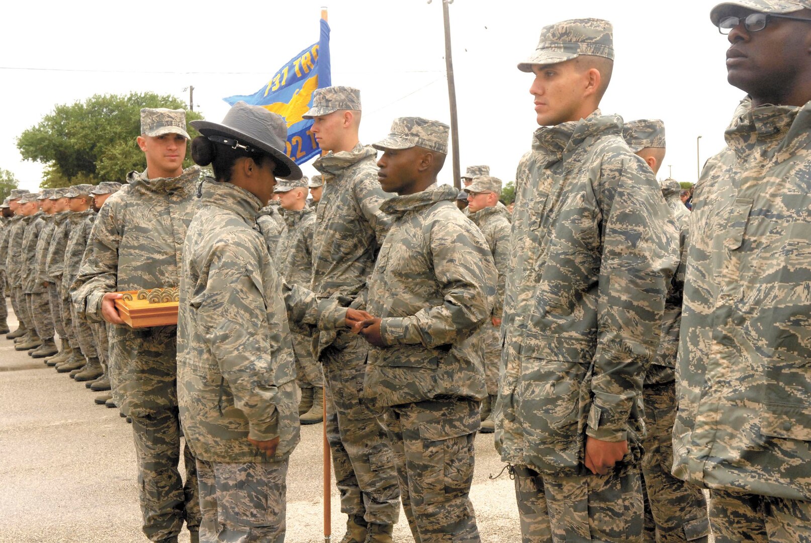 Trainees from 322nd Training Squadron Flight 287 receive coins from their military training instructor team chief, Staff Sgt. Katrevious Swift, during the retreat ceremony April 18 at Joint Base San Antonio-Lackland.