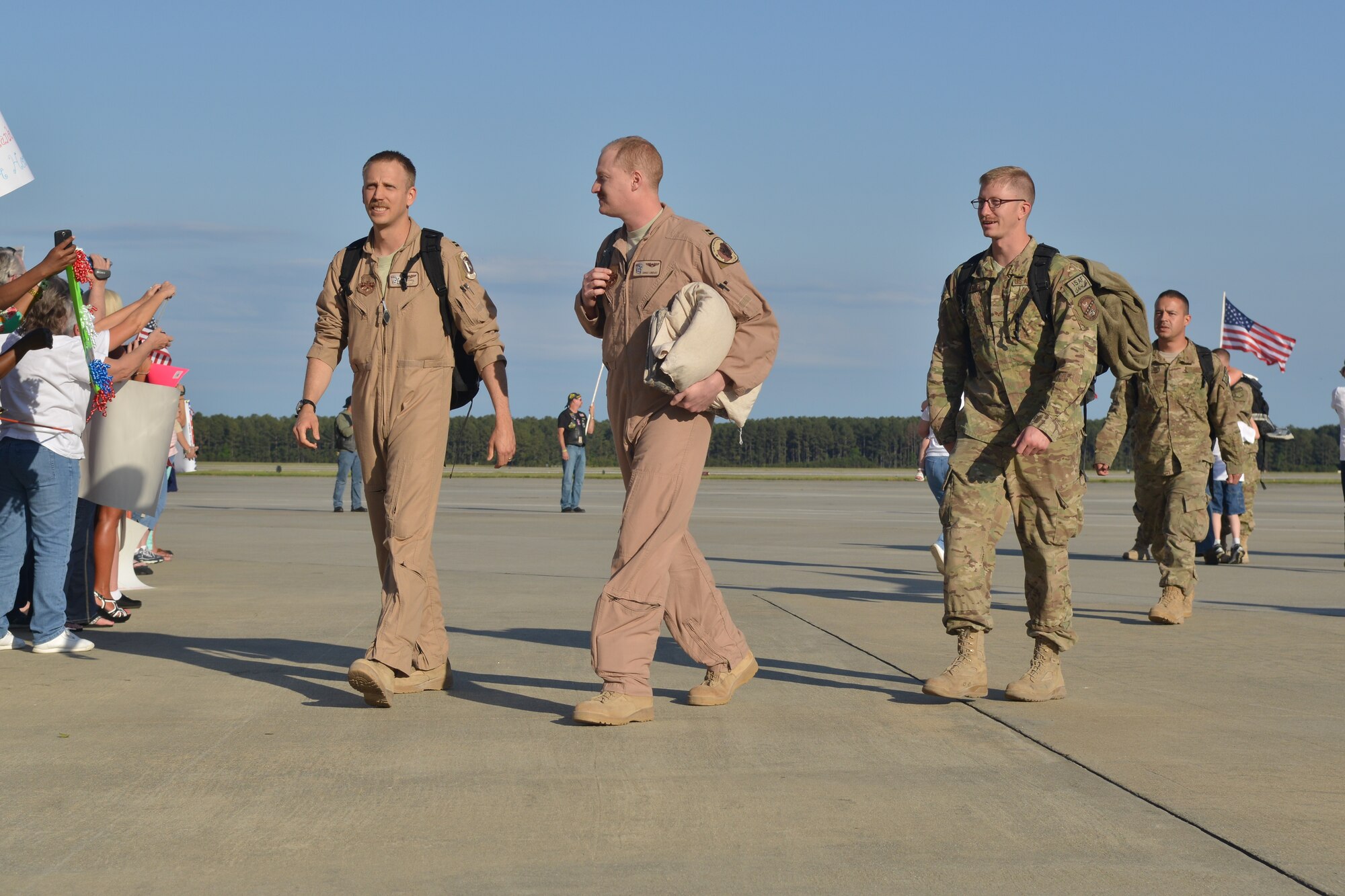 Airmen assigned to the 77th Fighter Squadron arrive after a six month deployment in Afghanistan at Shaw Air Force Base, S.C., April 25, 2013. More than 400 family members and friends gathered with U.S. flags welcoming their loved ones with hugs and signs. (U.S Air Force photo by Airman 1st Class Ashley L. Gardner/Released)