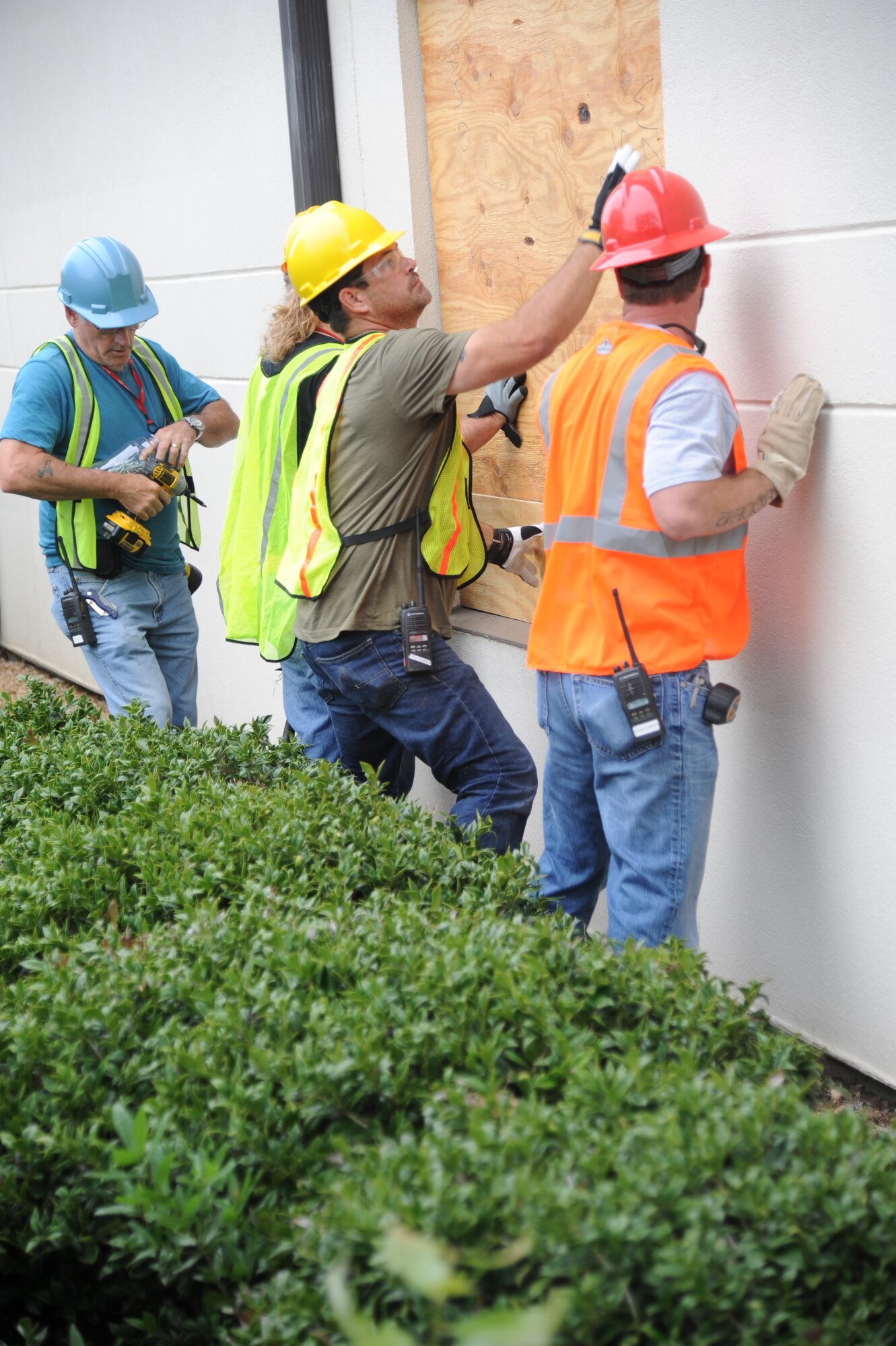 Computer Sciences Corporation contractors board up windows and doors on the 2nd Air Force building during a hurricane exercise April 24, 2013, at Keesler Air Force Base, Miss.  Throughout the exercise, “Hurricane Hana” brought severe thunderstorms, F2 tornado strength winds, rain and hail damage to several base facilities.  The purpose of the exercise was to prepare Keesler for the upcoming hurricane season.  (U.S. Air Force photo by Kemberly Groue)