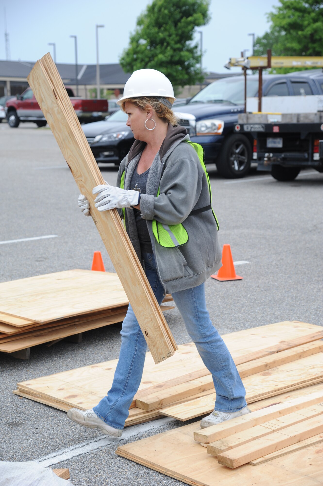 Susan Frentz, Computer Sciences Corporation contractor, carries boards to “harden” doors and windows on the 2nd Air Force building during a hurricane exercise April 24, 2013, at Keesler Air Force Base, Miss.  Throughout the exercise, “Hurricane Hana” brought severe thunderstorms, F2 tornado strength winds, rain and hail damage to several base facilities.  The purpose of the exercise was to prepare Keesler for the upcoming hurricane season.  (U.S. Air Force photo by Kemberly Groue)