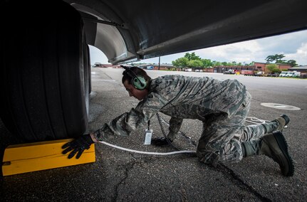 Airman 1st Class Matthew Taresh, 437th Aircraft Maintenance Squadron crew chief, chalks the tires of the a new C-17 Globemaster III after being delivered by  Gen. Paul Selva, Air Mobility Command commander April 25, 2013, at Joint Base Charleston – Air Base, S.C. Joint Base Charleston is scheduled to receive two additional C-17s this year, as Boeing completes work on the Air Force’s final Globemasters. The first C-17 to enter the Air Force’s inventory arrived at Charleston Air Force Base in June 1993.The C-17 is capable of rapid strategic delivery of troops and all types of cargo to main operating bases or directly to forward bases in the deployment area. (U.S. Air Force photo/ Senior Airman Dennis Sloan)