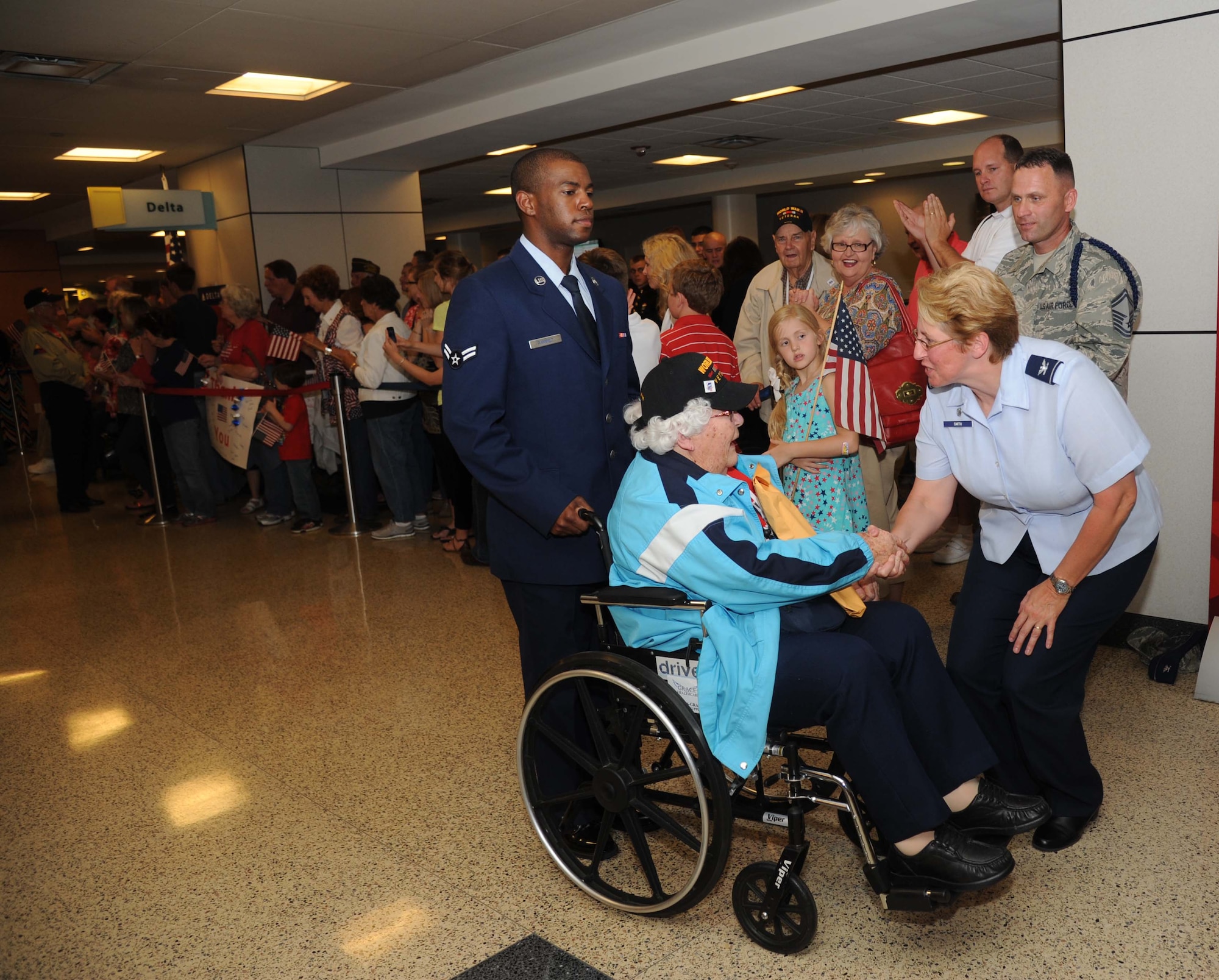 Airman First Class Virgilio Ramirez, 336th Training Squadron, escorts Earlene Syverson, World War II veteran, as Col. Maureen Smith, 81st Training Group commander, and Senior Master Sgt. Anthony Fisher, 81st TRG, thank her for her service at the fifth Mississippi Gulf Coast Honor Flight to Washington, D.C., April 23, 2013, at the Gulfport/Biloxi International Airport.  The Honor Flight program honors our nation’s World War II veterans by sending them on a one-day visit to various monuments in Washington, D.C.  (U.S. Air Force photo by Kemberly Groue)