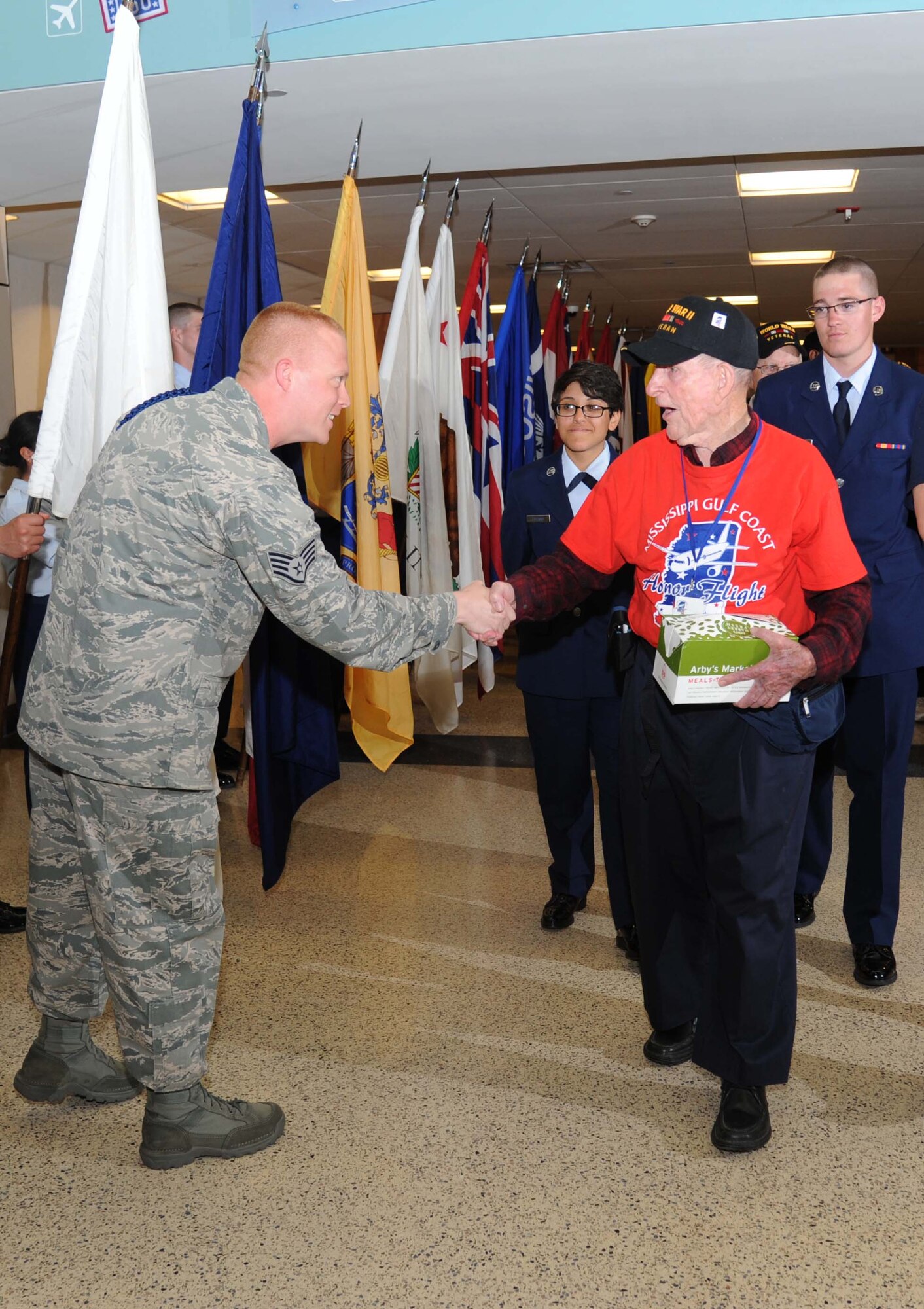 Staff Sgt. Tim Hite, 335th Training Squadron, gives thanks to Daniel Vliet, World War II veteran, for his service as Airmen Basic Lauren Lozano, 336th TRS, and Michael Volkmeier, 338th TRS, escort him at the fifth Mississippi Gulf Coast Honor Flight to Washington, D.C., April 23, 2013, at the Gulfport/Biloxi International Airport.  The Honor Flight program honors our nation’s World War II veterans by sending them on a one-day visit to various monuments in Washington, D.C.  (U.S. Air Force photo by Kemberly Groue)