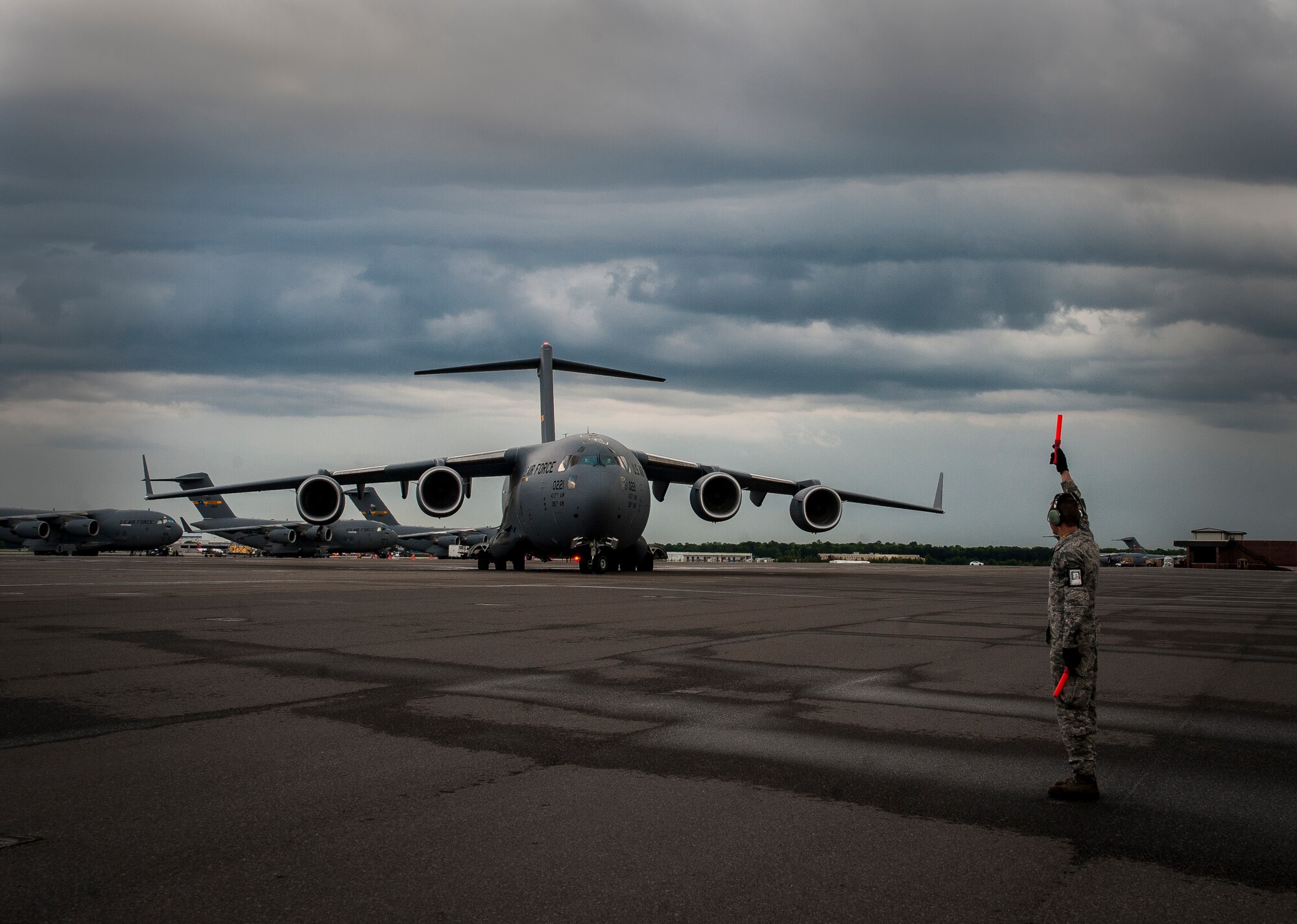 Senior Airman Eric Halchak, 437th Aircraft Maintenance Squadron crew chief, marshals in a brand new C-17 Globemaster III flown by Gen. Paul Selva, Air Mobility Command commander April 25, 2013, at Joint Base Charleston, S.C. Joint Base Charleston is scheduled to receive two additional C-17s this year, as Boeing completes work on the Air Force’s final Globemasters. The first C-17 to enter the Air Force’s inventory arrived at Charleston Air Force Base in June 1993. The C-17 is capable of rapid strategic delivery of troops and all types of cargo to main operating bases or directly to forward bases in the deployment area. (U.S. Air Force photo/ Senior Airman Dennis Sloan)