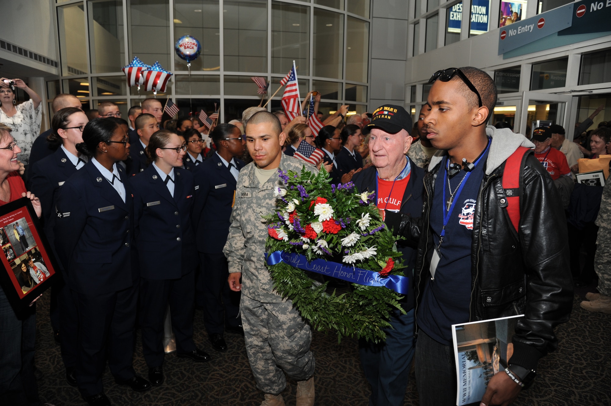 Alvin Plaeger, World War II veteran, carries a wreath at the fifth Mississippi Gulf Coast Honor Flight to Washington, D.C., April 23, 2013, at the Gulfport/Biloxi International Airport.  The Honor Flight program honors our nation’s World War II veterans by sending them on a one-day visit to various monuments in Washington, D.C.  (U.S. Air Force photo by Kemberly Groue)