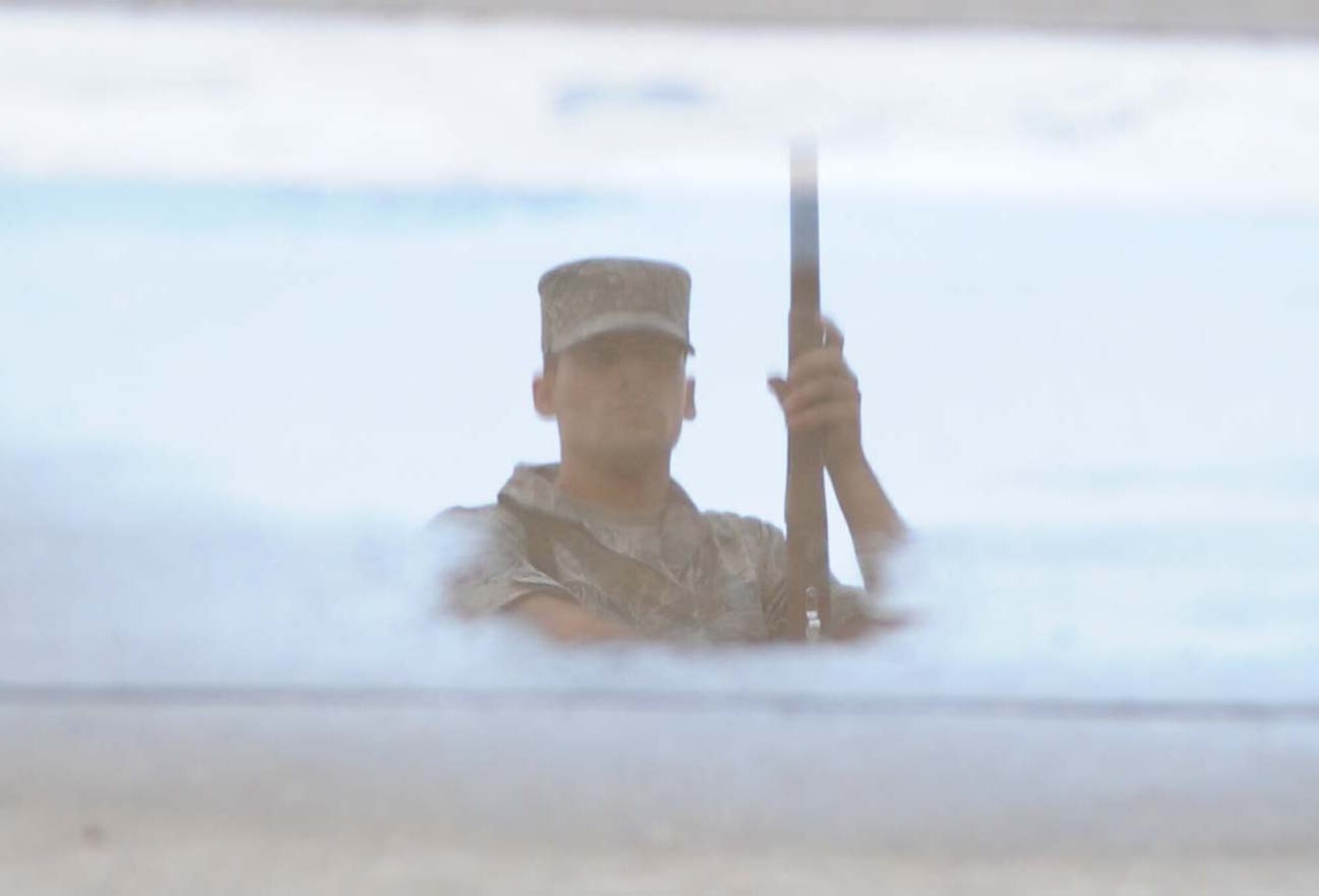 A reflection of a member of the 336th Training Squadron is seen in rain puddle during a performance in the freestyle drill competition during the 81st Training Group drill down performance April 24, 2013, at Keesler Air Force Base, Miss.  The 336th TRS placed third in the open ranks portion of the drill down.  (U.S. Air Force photo by Kemberly Groue)