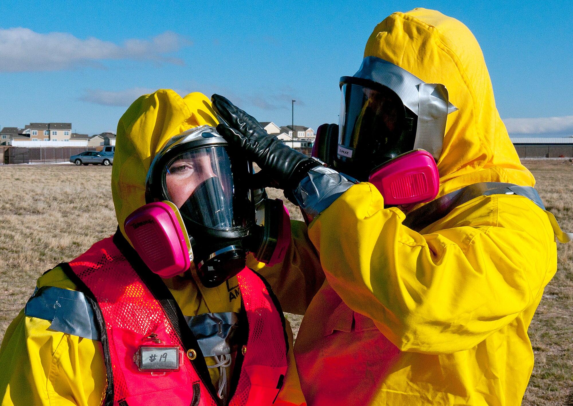 Airman 1st Class John Zuhlke helps Senior Airman Kristen Towns, 90th Medical Operations Squadron bioenvironmental engineering, secure her respirator as they prepare to work in a decontamination area during an exercise on F. E. Warren Air Force Base April 12. The exercise was part of a Nuclear Surety Inspection or the 90th Missile Wing by the Air Force Global Strike Command Inspector General Team. (U.S. Air Force photo by R.J. Oriez)