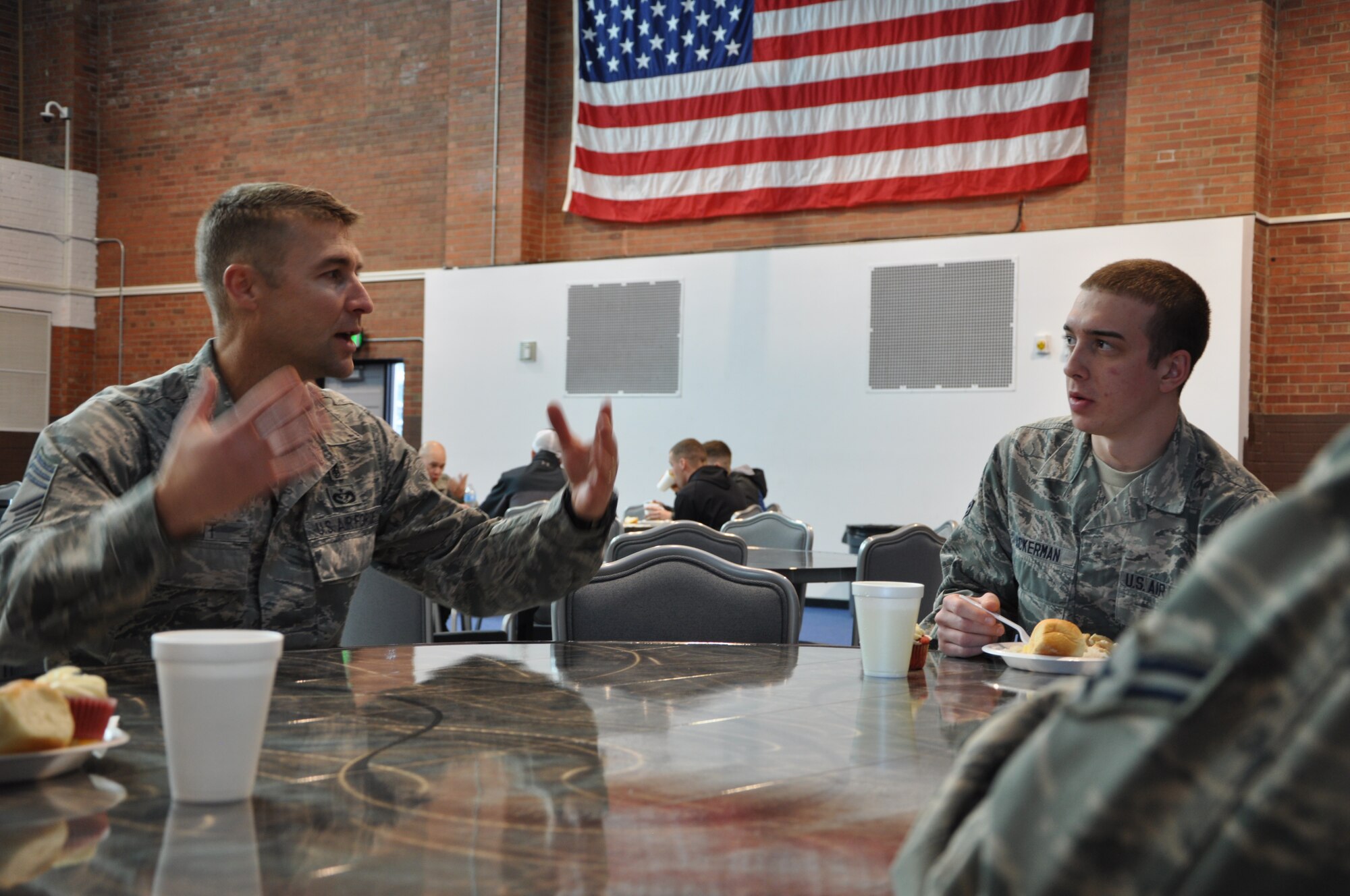 Chief Master Sgt. Conrad Stott, 90th Medical Group superintendent, speaks with Airman 1st Class Ryan Ackerman, 90th Missile Maintenance Squadron, during April’s dorm dinner held in the Fall Hall Community Center. The 90th MDG worked in cooperation with the 90th Missile Wing Chaplain’s office to host the dinner April 18, which featured a raffle for door prizes while dinner included teriyaki chicken, rice and pineapples. (U.S. Air Force photo by Senior Airman Daniel Gage)