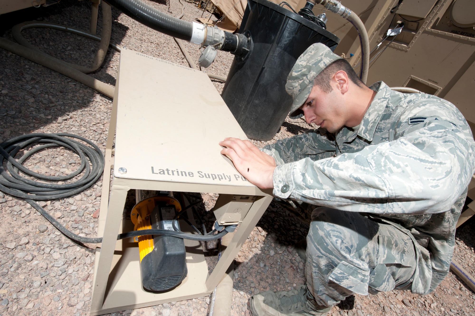 Airman 1st Class Vahagn Poghosyan, 49th Materiel Maintenance Squadron water and fuels system maintainer, repairs a water supply pump for a new hygiene system at Holloman Air Force Base, N.M., April 24. The 49th MMS was the first unit to receive and test the new hygiene system, complete with latrines and showers, which will eventually be utilized in forward deployed locations. (U.S. Air Force photo by Airman 1st Class Daniel E. Liddicoet)
