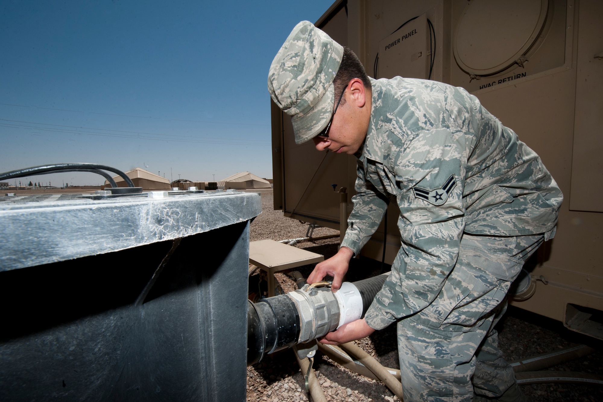 Airman 1st Class Trevor Dickerson, 49th Materiel Maintenance Squadron water and fuels system maintainer, removes a pump from a macerator used for the new hygiene system at Holloman Air Force Base, N.M., April 24. The 49th MMS was the first unit to receive and test the new hygiene system, complete with latrines and showers, which will eventually be utilized in forward deployed locations. (U.S. Air Force photo by Airman 1st Class Daniel E. Liddicoet)
