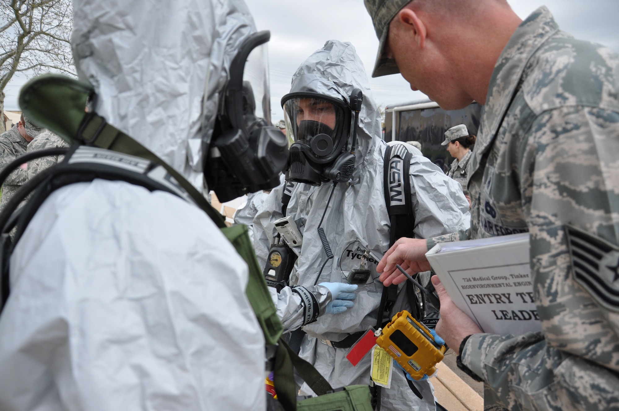 Tech. Sgt. Lance Johnston performs a final gear check on Bioenvironmental Engineering CBRN response entry team members Senior Airmen Justin Sims, left, and Justin Andrews before they enter into an unknown hazardous environment. A joint Bioenvironmental Engineering and Emergency Management team performed a health risk assessment during this week’s Disease Containment Plan exercise. (Air Force photo by Brion Ockenfels)