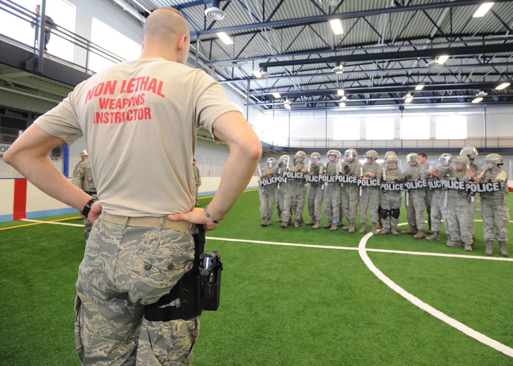 Staff Sgt. Christopher Giles, non-lethal weapons instructor with the 319th Security Forces Squadron, trains a flight how to form a “squad echelon right” on April 9, 2013, at Grand Forks Air Force Base, N.D.  A squad echelon right is a non-lethal weapons tactic used by law enforcement during riots. (U.S. Air Force photo/Airman 1st Class Xavier Navarro)