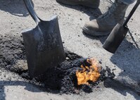 Heavy equipment operators from the 319th Civil Engineer Squadron work to fill potholes in the road on April 23, 2013, at Grand Forks Air Force Base, N. D. Heavy equipment operators ensure base roads are smooth and safe for base travelers such as motorcycle riders, who look to take advantage of warmer temperatures forecasted for the week. (U.S. Air Force photo/Airman 1st Class Ashley Nicole Taylor)