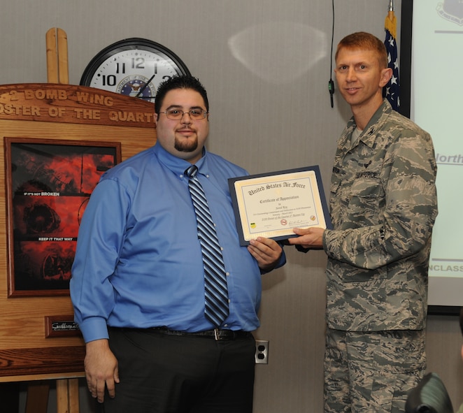 Col. Reid Langdon, 2nd Bomb Wing vice commander, presents a certificate of recognition to Jared Roy, a student from Northwestern State University of Louisiana, Natchitoches, La.,  for his runner-up foreign object debris or "FOD" poster submission at Barksdale Air Force Base, La., April 24, 2013. The FOD poster contest is used to promote awareness and help reduce the number of FOD incidents that caused more than $3 million of damage the past 5 years. (U.S. Air Force photo/Airman 1st Class Benjamin Gonsier)