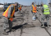 Heavy equipment operators from the 319th Civil Engineer Squadron work to fill potholes in the road on April 23, 2013, at Grand Forks Air Force Base, N. D. Heavy equipment operators ensure base roads are smooth and safe for base travelers such as motorcycle riders, who look to take advantage of warmer temperatures forecasted for the week. (U.S. Air Force photo/Airman 1st Class Ashley Nicole Taylor)