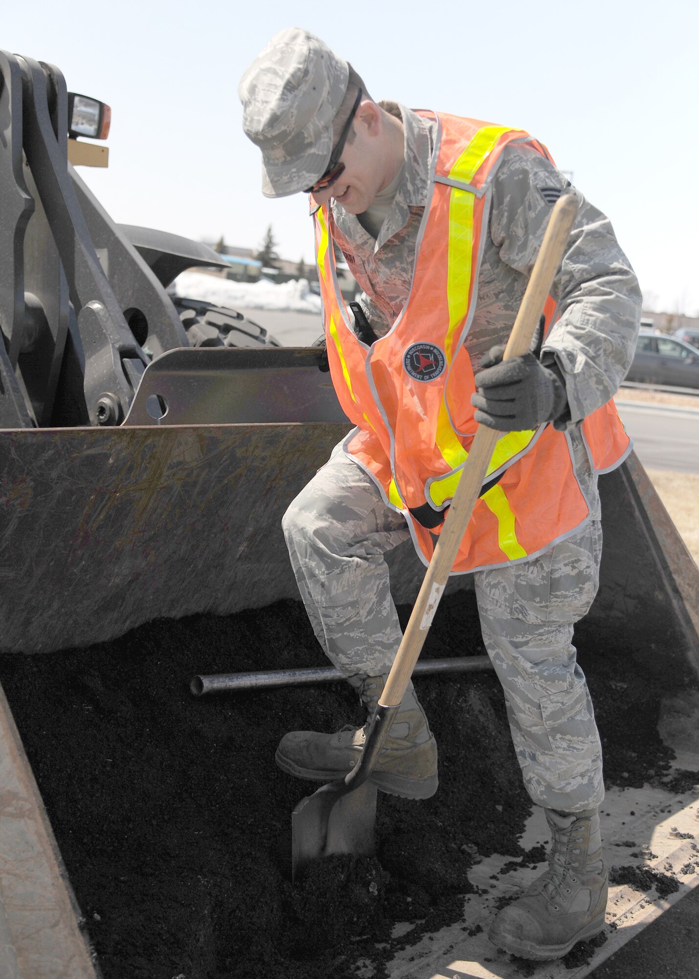 Senior Airman Cody Salisbury, 319th Civil Engineer Squadron heavy equipment operator, gathers asphalt to fill a pothole on April 23, 2013, at Grand Forks Air Force Base, N. D. Heavy equipment operators ensure base roads are smooth and safe as the number of vehicles traveling on roadways increases due to warmer temperatures. (U.S. Air Force photo/Airman 1st Class Ashley Nicole Taylor)  
