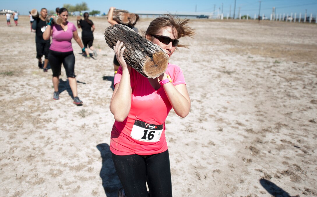 Claudia Marino carries a log from one point to another in Del Rio’s Battle on the Border Mud Crawl at the Val Verde County Fairgrounds April 20, 2013. The Mud Crawl was a two-mile course that held several obstacles and challenges for each participant. (U.S. Air Force photo/Airman 1st Class John D. Partlow)