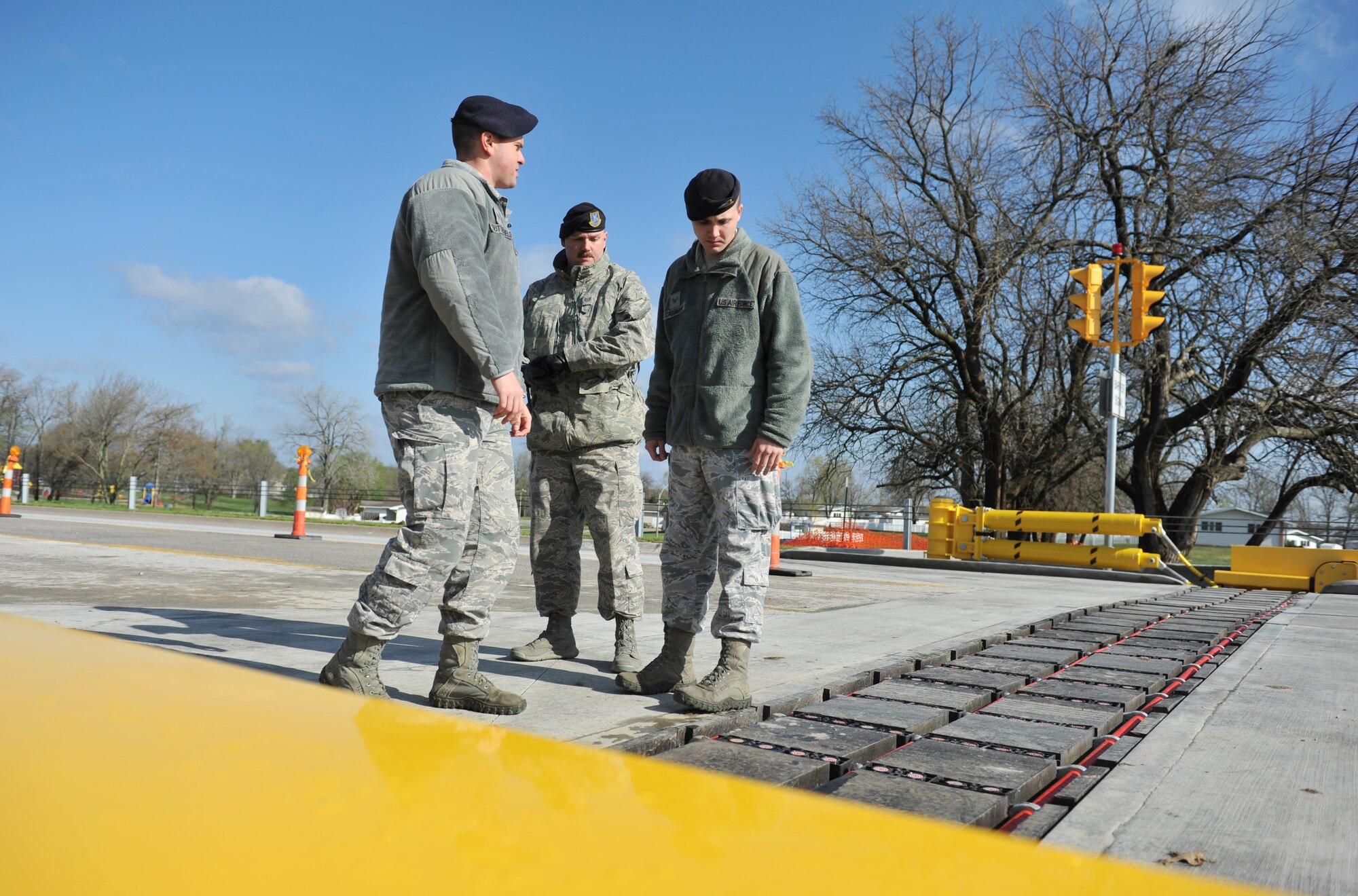 Staff Sgt. Stephen Sutterfield, 509th Security Forces Squadron NCO in charge of confinement facility and alternate NCO in charge on police services; Tech. Sgt. Gregory Bowman, 509th SFS NCO in charge police services; and Senior Airman Christopher Cassmann, 509th SFS assistant police services, discuss training methods about the new, non-lethal net barrier system April 24, 2013, at Whiteman Air Force Base, Mo. The barrier system is designed to keep unauthorized vehicles off the installation and reduces risk to security forces when conducting vehicle inspections. (U.S. Air Force photo by Heidi Hunt/Released)
