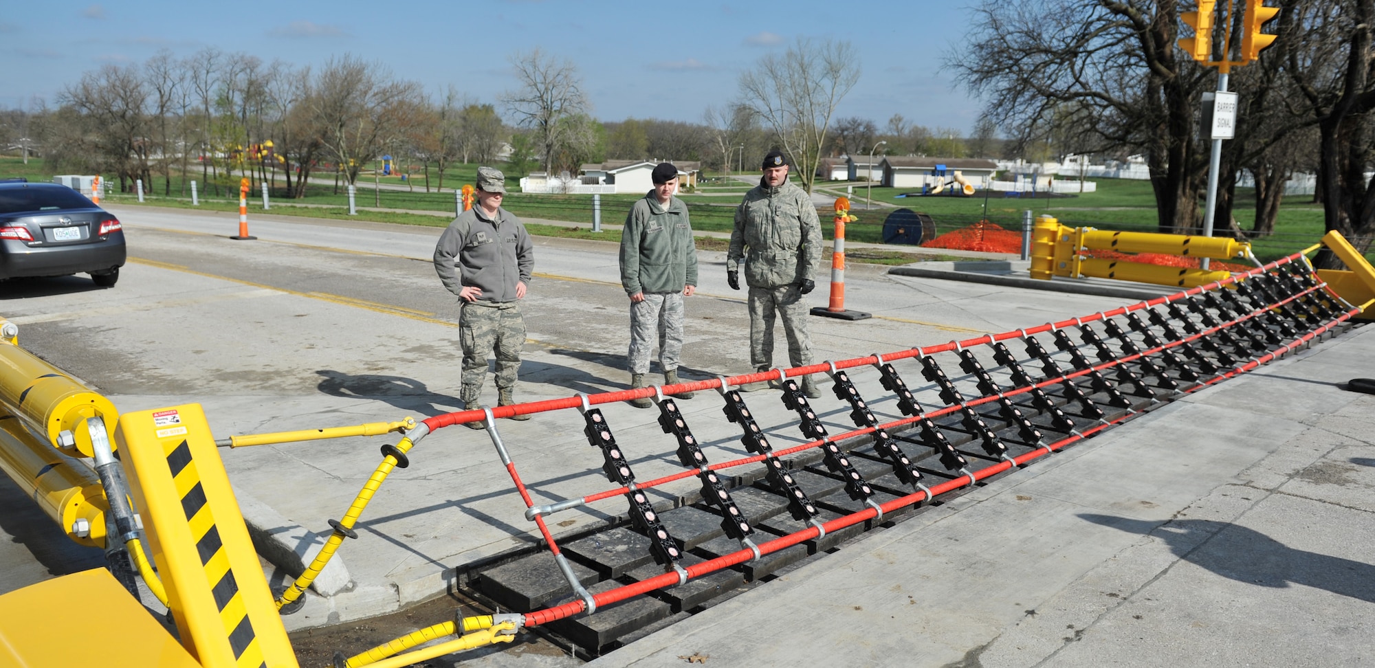 Staff Sgt. Jennifer Winkels, 509th Civil Engineer Squadron project manager; Senior Airman Christopher Cassmann, 509th Security Forces Squadron assistant police services; Tech. Sgt. Gregory Bowman, 509th SFS NCO in charge police services; watch as the barrier system is tested April 24, 2013, at Whiteman Air Force Base, Mo. The system includes a new, non-lethal net barrier system, additional anti-ram cables and two new inspection lanes. (U.S. Air Force photo by Heidi Hunt/Released)