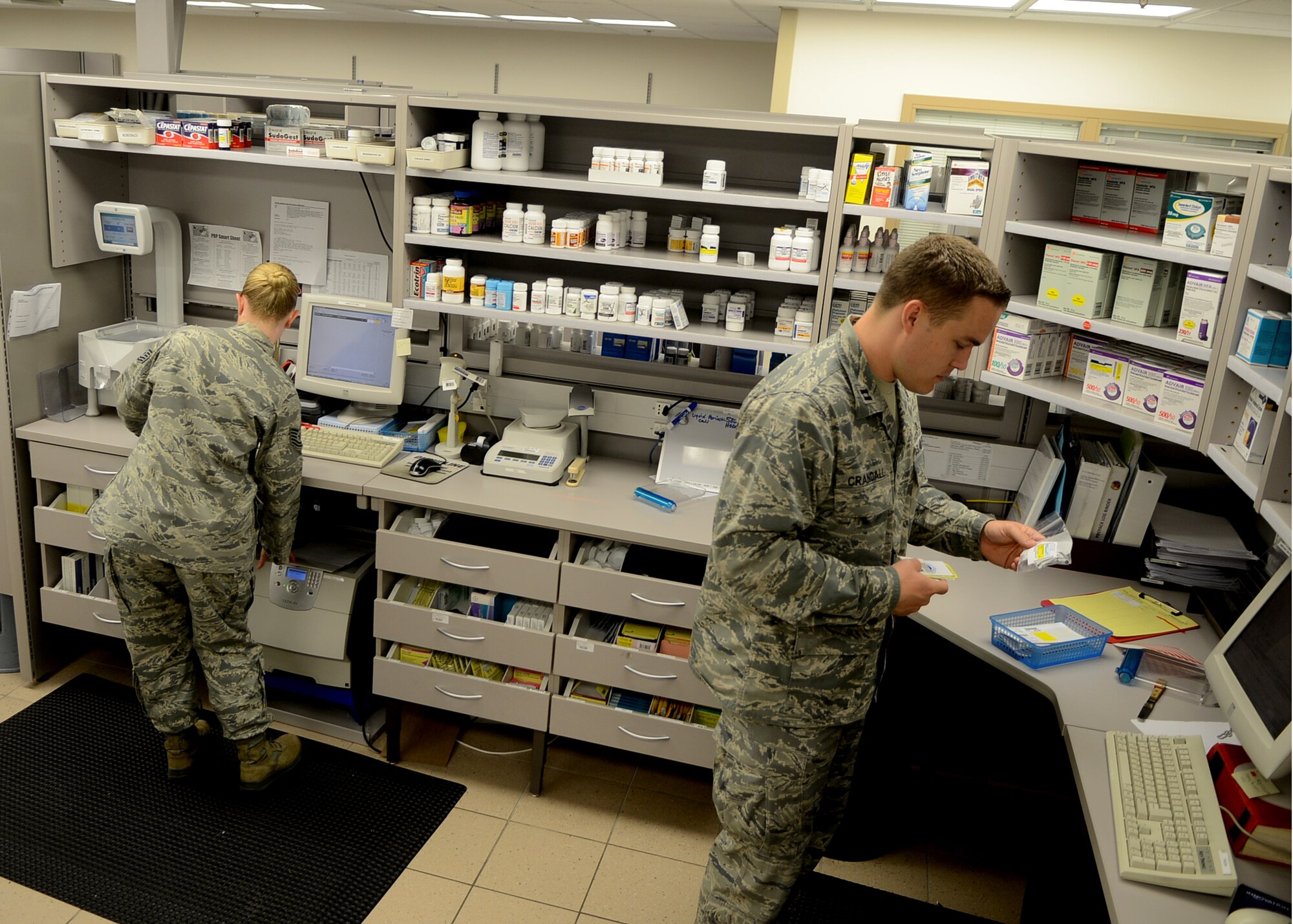 (Left) Tech Sgt. Leah Lewis and Capt. Benjamin Crandall prepare and fill prescriptions in the pharmacy April 23, 2012, at Aviano Air Base, Italy. Members of the 31st MDSS provide resource and health plan management, patient administration, medical logistics and readiness, medical information and pharmacy services and clinical laboratory services. Lewis is the NCO in charge of inpatient pharmacy for the 31st Medical Support Squadron. Crandall is the officer in charge of inpatient pharmacy for the 31st MDSS.  (U.S. Air Force photo illustration/Airman 1st Class Jenay Randolph)