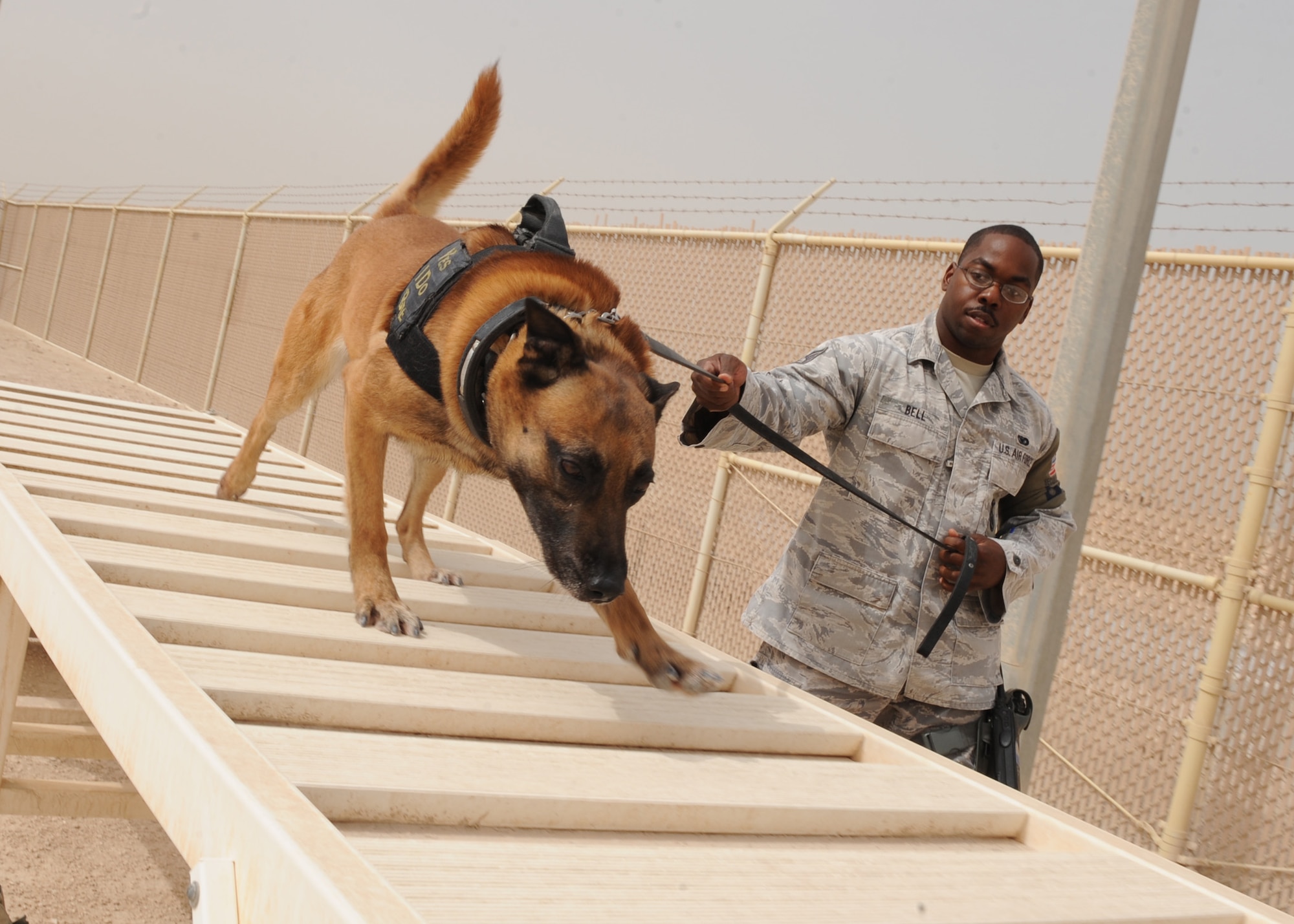 SOUTHWEST ASIA – Staff Sgt. Charles Bell and his military working dog, Nico, get some exercise at the obstacle course in the obedience yard, April 23. Nico is a Belgium Malinois and has been in the Air Force working dog program for four years. Bell is assigned to the 379th Expeditionary Security Forces Squadron as a dog handler and both are deployed from Travis Air Force Base, Calif. (U.S. Air Force photo/Staff Sgt. Joel Mease)
