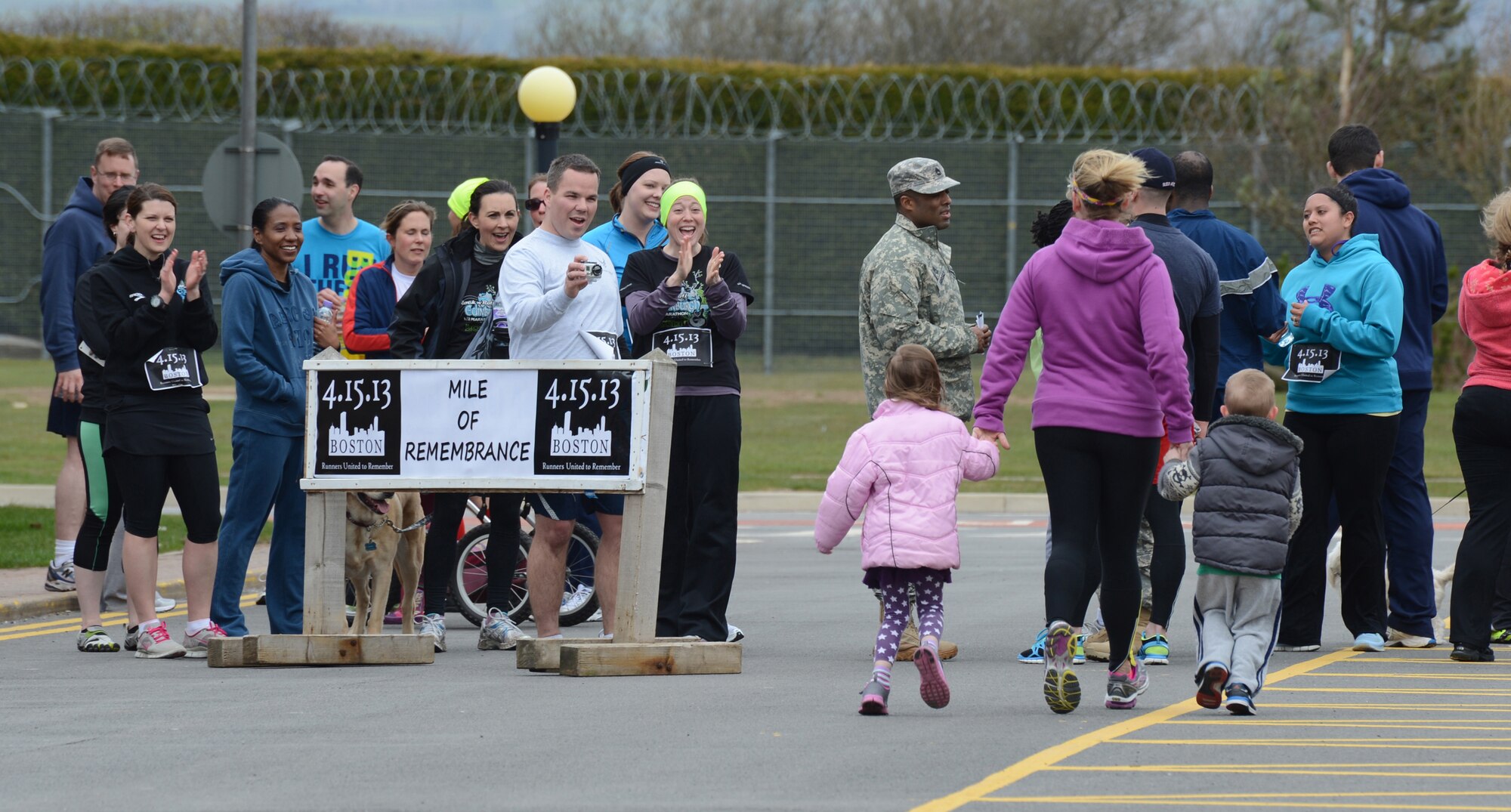 RAF MENWITH HILL, United Kingdom – Members of the Menwith Hill Station community cheer as participants finish the “Boston Mile,” a mile of remembrance, which was held April 22 in order to honor and show support to the victims of the Boston Marathon bombing April 15. Roughly 80 people from around base joined together to run or walk in remembrance. (U.S. Air Force photo by Staff Sgt. Debbie Lockhart)