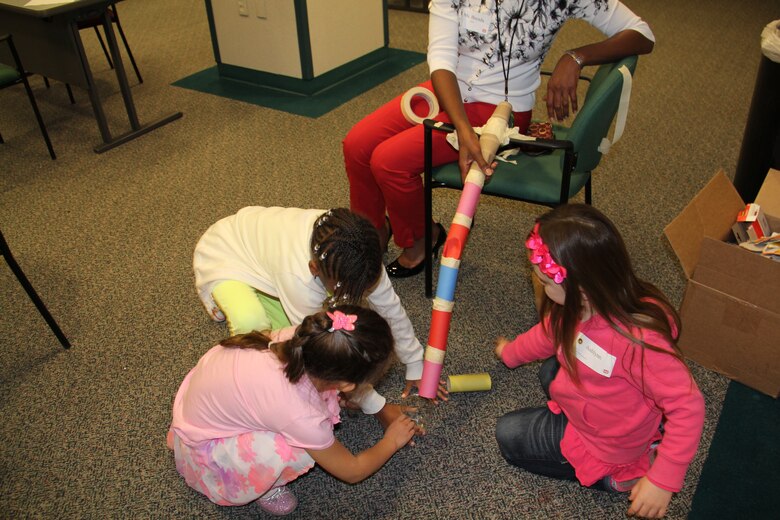 Children of employees at SWD participate in a roller coaster building activity during Take Your Sons and Daughters to Work Day. The young children had to build a roller coaster out of tolilet paper rolls and then drop a marble down it to see if it would work.