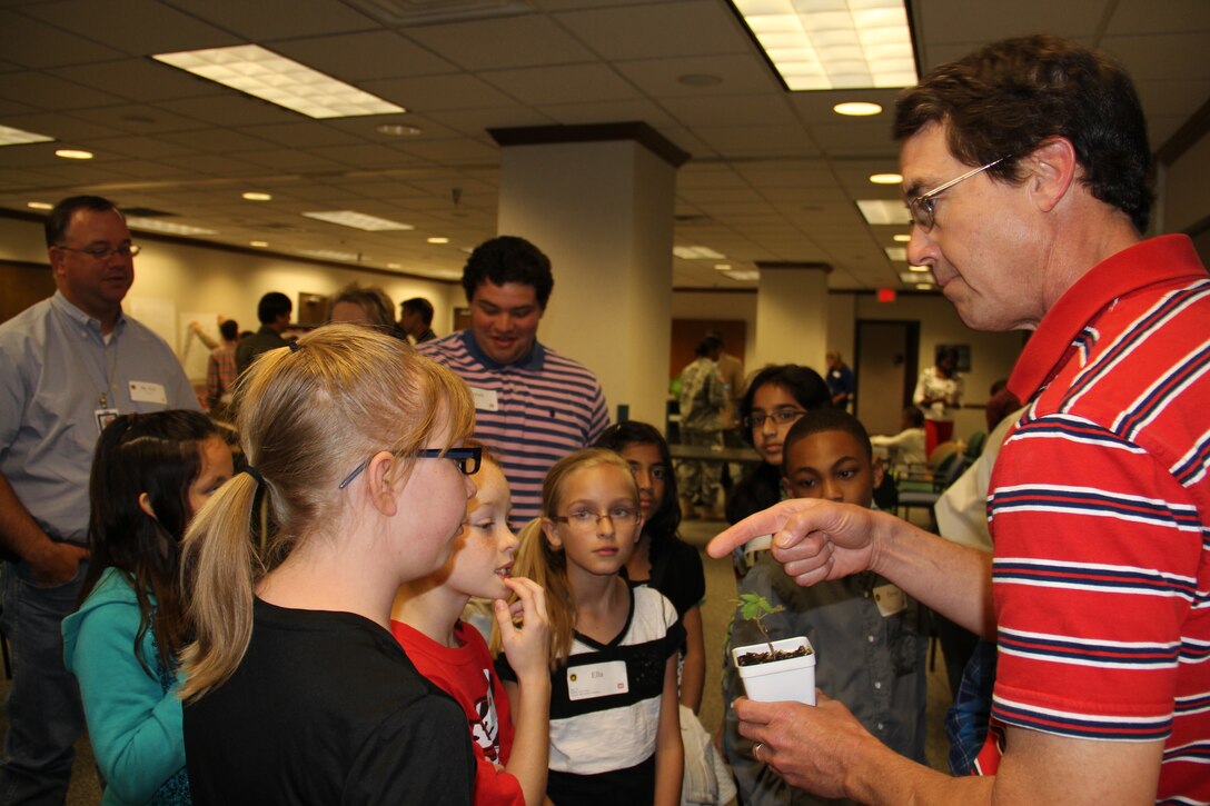 Randy Roberts, an SWD real estate program manager, teaches children about photosynthesis during Take Your Sons and Daughters to Work Day.