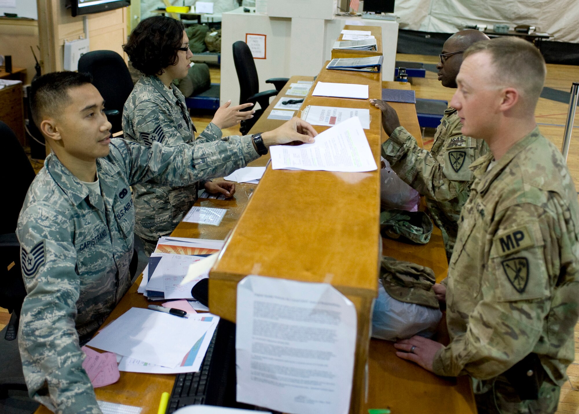 Tech. Sgt. Christian Capistrano, 376th Expeditionary Logistics Readiness Squadron air transportation specialist, and Tech Sgt. Dina Pena-Hernandez 376 ELRS passenger counter supervisor, assist customers April 27, 2013, at Transit Center at Manas, Kyrgyzstan. Capistrano is deployed from Homestead Air Reserve Base, Fla., and is a native of Fort Lauderdale, Fla. Pena-Hernandez is deployed from Homestead, Fla., and is a native of Boca Raton, Fla. (U.S. Air Force photo/Staff Sgt. Stephanie Rubi)