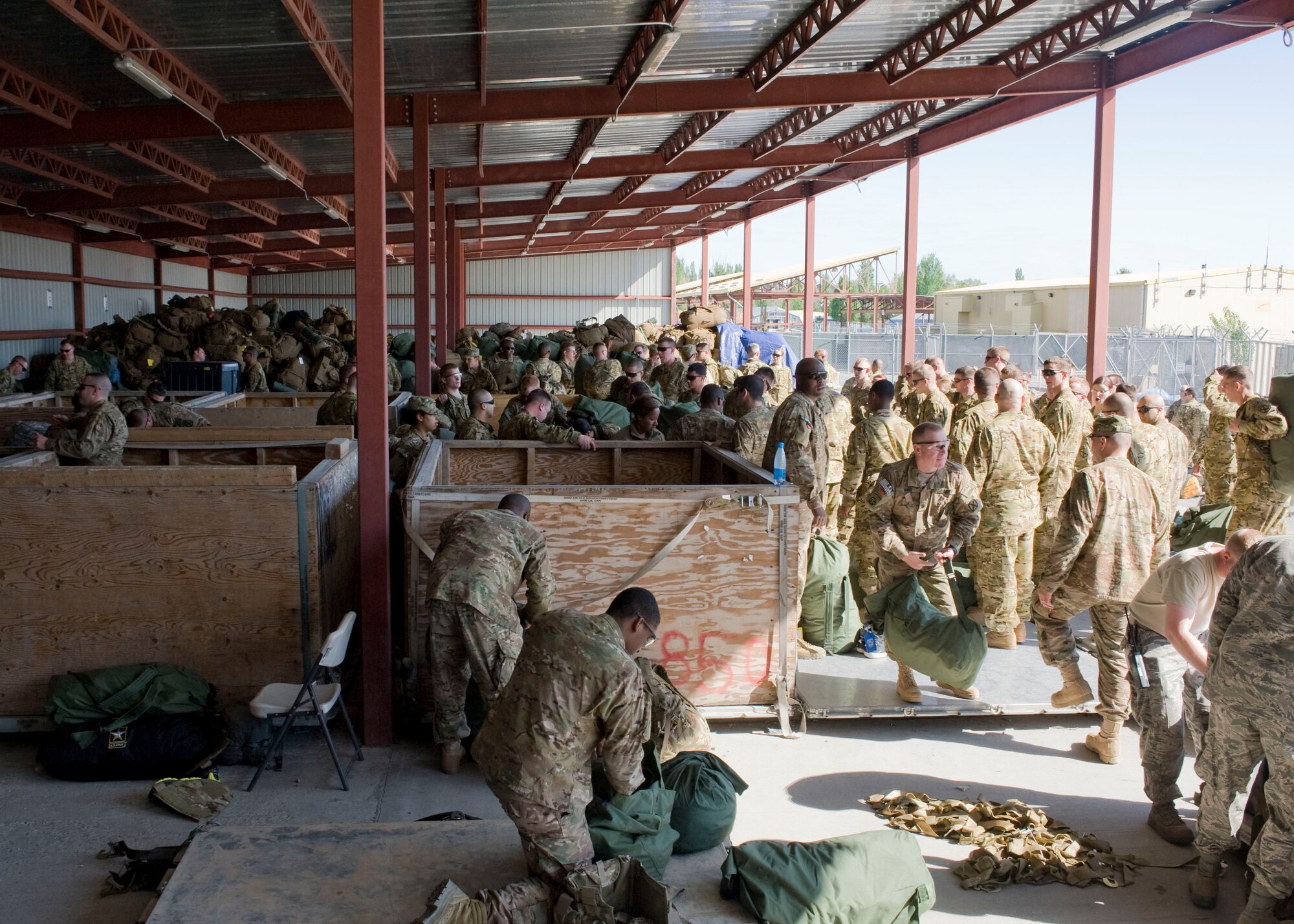 U.S. Army transients unload baggage outside the passenger terminal April 27, 2013, at Transit Center at Manas, Kyrgyzstan. Troops heading downrange typically arrive at the Transit Center on commercial aircraft where their baggage is loosely loaded in the cargo department. Baggage must be downloaded from the aircraft, separated based on final downrange destination and palletized for the military aircraft that will transport them there. (U.S. Air Force photo/Staff Sgt. Stephanie Rubi) 