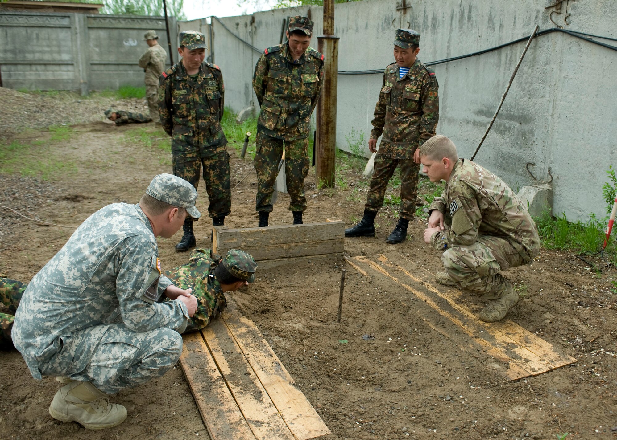 U.S. Armed Forces and Kyrgyz Republic Ministry of Defense explosive ordnance disposal team members, work together to practice uncovering landmines during an EOD military exchange April, 24, 2013, at Transit Center at Manas, Kyrgyzstan.  "We are developing a partnership with our host national counterparts," said Sgt. 1st Class James Garton, EOD Theater Security Cooperation event manager. "It's always a win when people can get together because we have so much to learn from one another." (U.S Air Force photo/Staff Sgt. Stephanie Rubi)