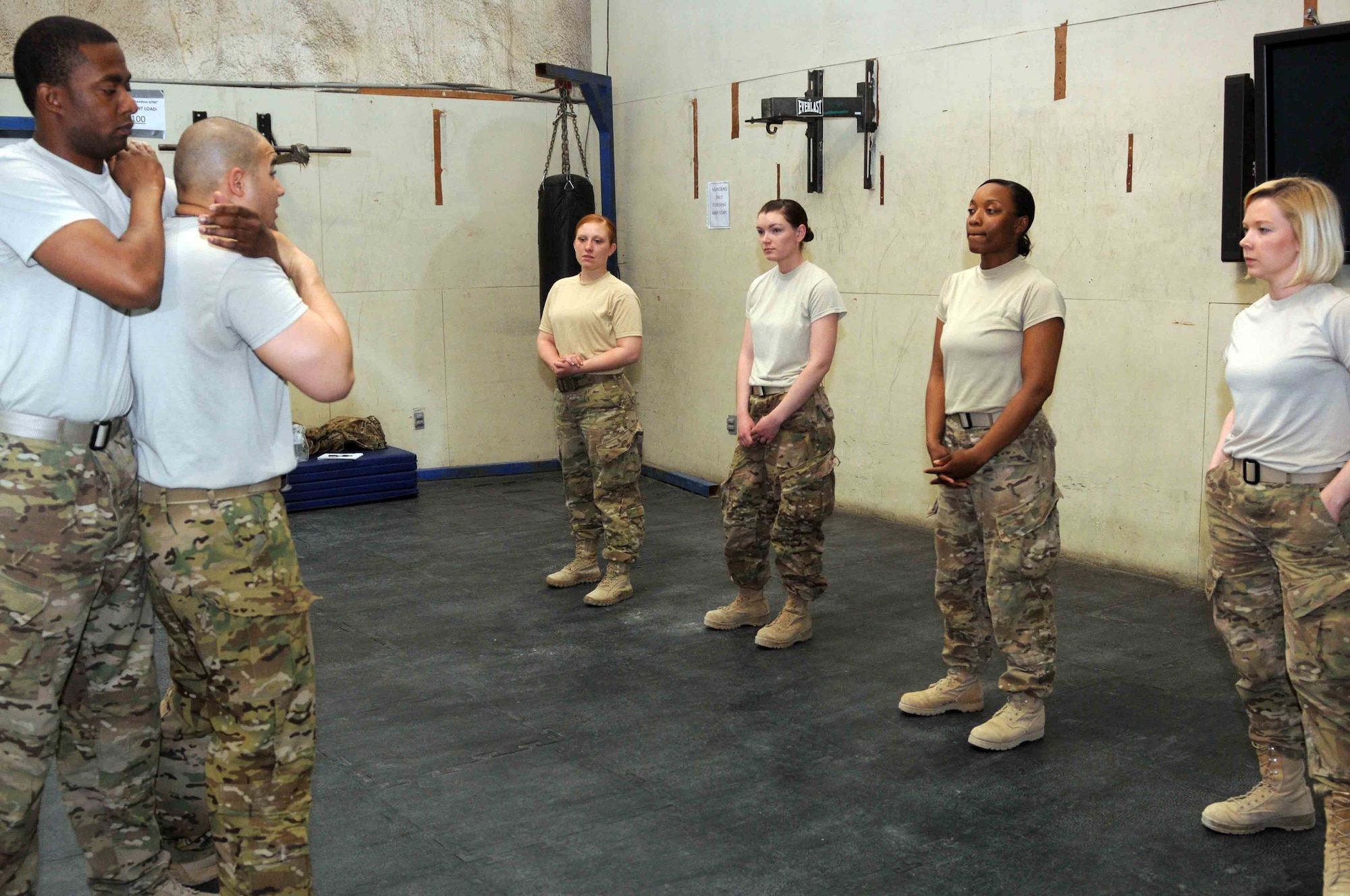 Tech Sgt. Erick Bergery Jr., 451st Expeditionary Security Forces Squadron senior combative instructor, demonstrates a possible response to a choke hold, April 9, from basic combative instructor Tech Sgt. Maurice Chaney during a self defense training event held at Kandahar Airfield, Afghanistan. (U.S. Army photo by Sgt. Lacey J. Hunt, 102nd MPAD)
