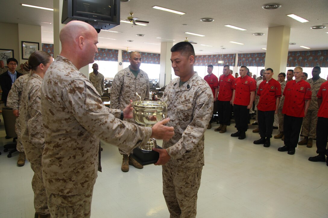 Col. Richard D. Hall, left, presents Master Sgt. Vichien Sornchan with a trophy April 24 at Camp Schwab for him and his Marines’ efforts in earning honors as large mess hall of the quarter for the second quarter of fiscal year 2013. As of the second quarter of FY 2013, mess halls are now separated into two categories for the competition. To win large mess hall of the quarter, a mess hall has to be able to seat more than 400 people. “This is a tough and demanding job which requires long hours of work, but these Marines continue to perform it with professionalism and pride,” said Hall, the commanding officer of 4th Marine Regiment, 3rd Marine Division, III Marine Expeditionary Force, and Camp Schwab commander. Sornchan is the Camp Schwab mess hall manager with Headquarters Company, 4th Marines. 