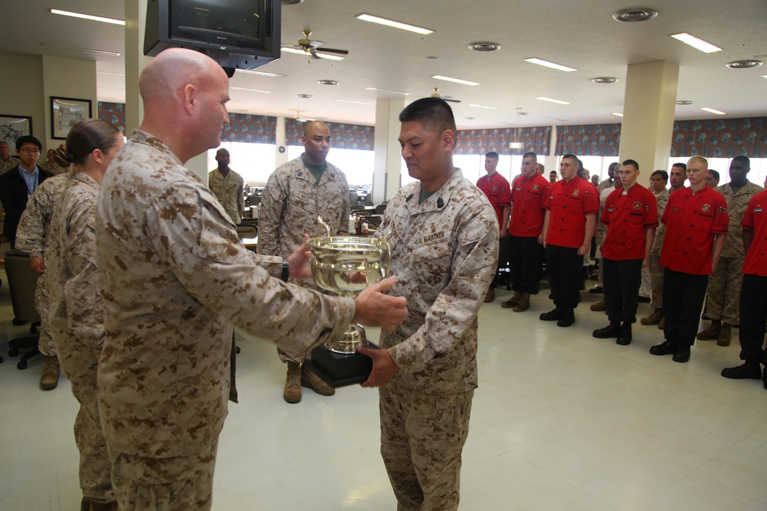 Col. Richard D. Hall, left, presents Master Sgt. Vichien Sornchan with a trophy April 24 at Camp Schwab for him and his Marines’ efforts in earning honors as large mess hall of the quarter for the second quarter of fiscal year 2013. As of the second quarter of FY 2013, mess halls are now separated into two categories for the competition. To win large mess hall of the quarter, a mess hall has to be able to seat more than 400 people. “This is a tough and demanding job which requires long hours of work, but these Marines continue to perform it with professionalism and pride,” said Hall, the commanding officer of 4th Marine Regiment, 3rd Marine Division, III Marine Expeditionary Force, and Camp Schwab commander. Sornchan is the Camp Schwab mess hall manager with Headquarters Company, 4th Marines. 