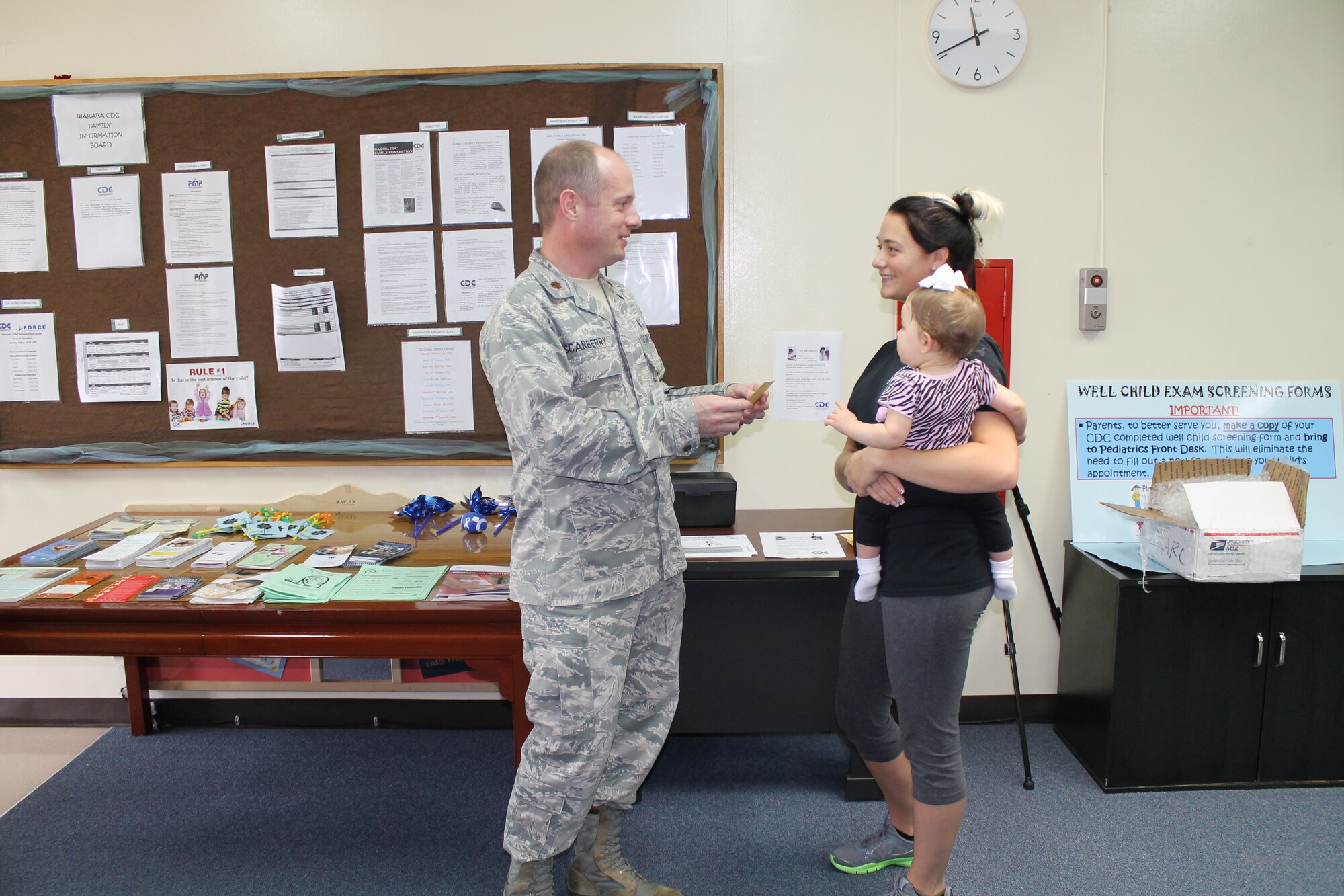 U.S. Air Force Maj. (Dr.) Jerel Scarberry, Kadena Pediatric Clinic and child development center medical director, answers a patron’s question during a Month of the Military Child event on Kadena Air Base, Japan, April 19, 2013. The event included a parent education table created by Valerie Seitz, family advocacy outreach coordinator, which provided information on raising healthy children. (Courtesy photo)