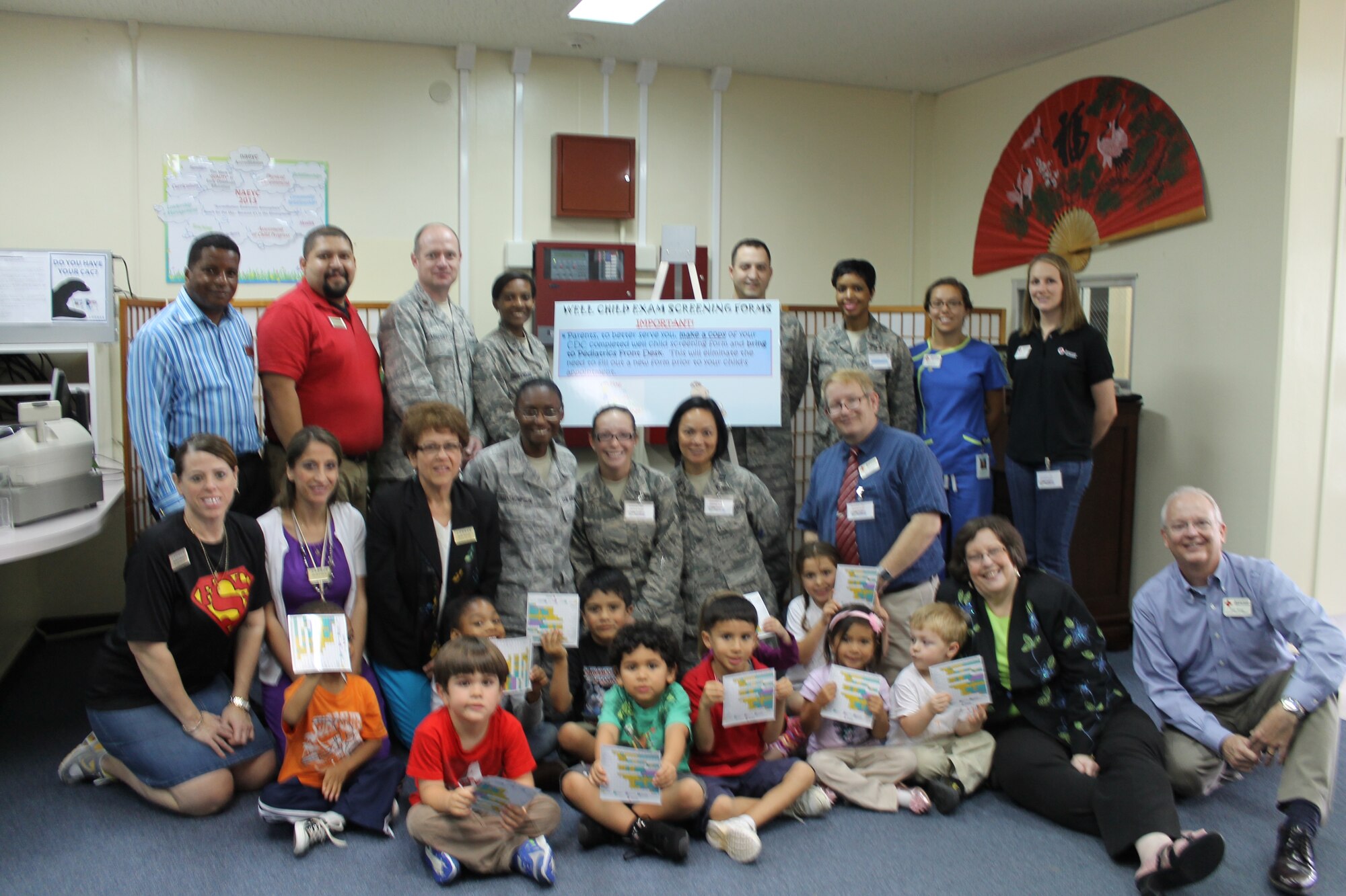 Kadena child development center children and employees, Kadena Red Cross volunteers and Kadena Pediatric Clinic members display some of the information available during a Month of the Military Child event on Kadena Air Base, Japan, April 19, 2013. The event offered parents an opportunity to get first-hand medical information and educational information aimed at promoting raising healthy children. (Courtesy photo)