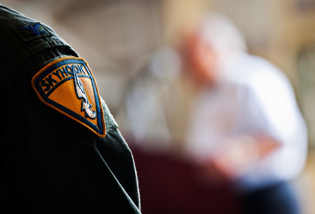 Col. Destry Rogers, the 919th Special Operations Wing vice commander, sports a Skyhook patch in honor of the Fulton Surface to Air Recovery System as retired Col. Ray Turczynski speaks during the retirement ceremony for the MC-130E Combat Talon I at Duke Field, Fla., April 25.  Turcynski spoke about 1980’s Operation Eagle Claw, the attempted mission to rescue hostages in Iran.  Aircrew, maintainers and many others turned out to remember and bid farewell to the Talon I on its official retirement from the Air Force.  The last five Talons, located at Duke Field, will be delivered to the “boneyard” at Davis-Monthan Air Force Base, N.M., by mid-May 2013.  (U.S. Air Force photo/Tech. Sgt. Samuel King Jr.)